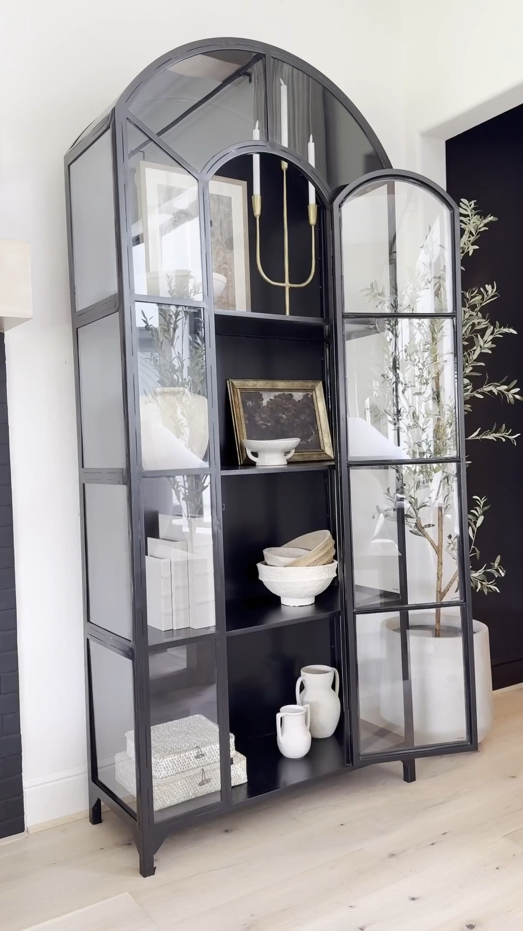 I’ve loved this classic cabinet for years plus it’s truly a timeless piece that feels heirloom-worthy. ☺️ I love the arched detail and glass panels that make it look like a work of art. 
I now have three in my home! Two in the sitting room and one in the family room — and honestly, I’d add more if I had the space 😬😍

It’s perfect for styling any room: dining area, next to a fireplace, bedroom, even an entryway. Solid and sturdy yet surprisingly easy to move. I love filling mine with neutral decor and adding a subtle pop of gold for warmth and contrast. A forever favorite 🖤#LTKStyleTip 


#LTKHome #LTKSaleAlert