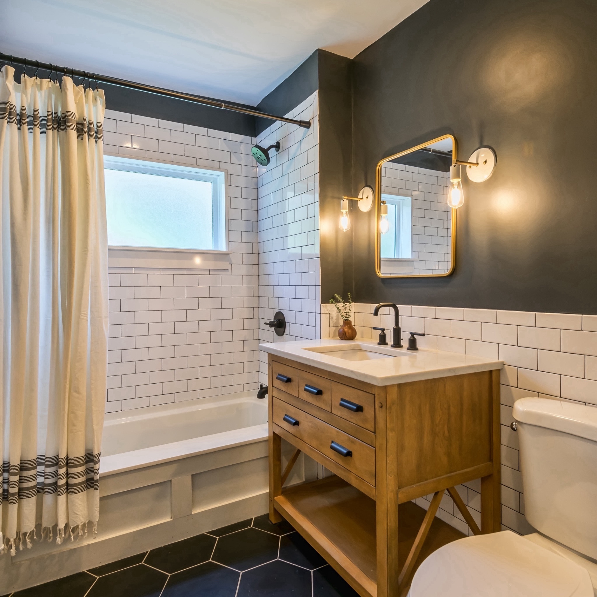 as much as we loved the powder blue 1960s style bathroom at the #sisterhouse, the fixtures were starting to rust and the plumbing needed to be updated. when redesigning the bathroom, our goal was to bring back classic finishes that tied in with the home's Craftsman roots. we opted for classic white subway tile, moody charcoal walls, and a beautiful pine vanity to give this bathroom a timeless look. head over to our blog for sources and more details on the transformation. #dwelloctober

#LTKhome
