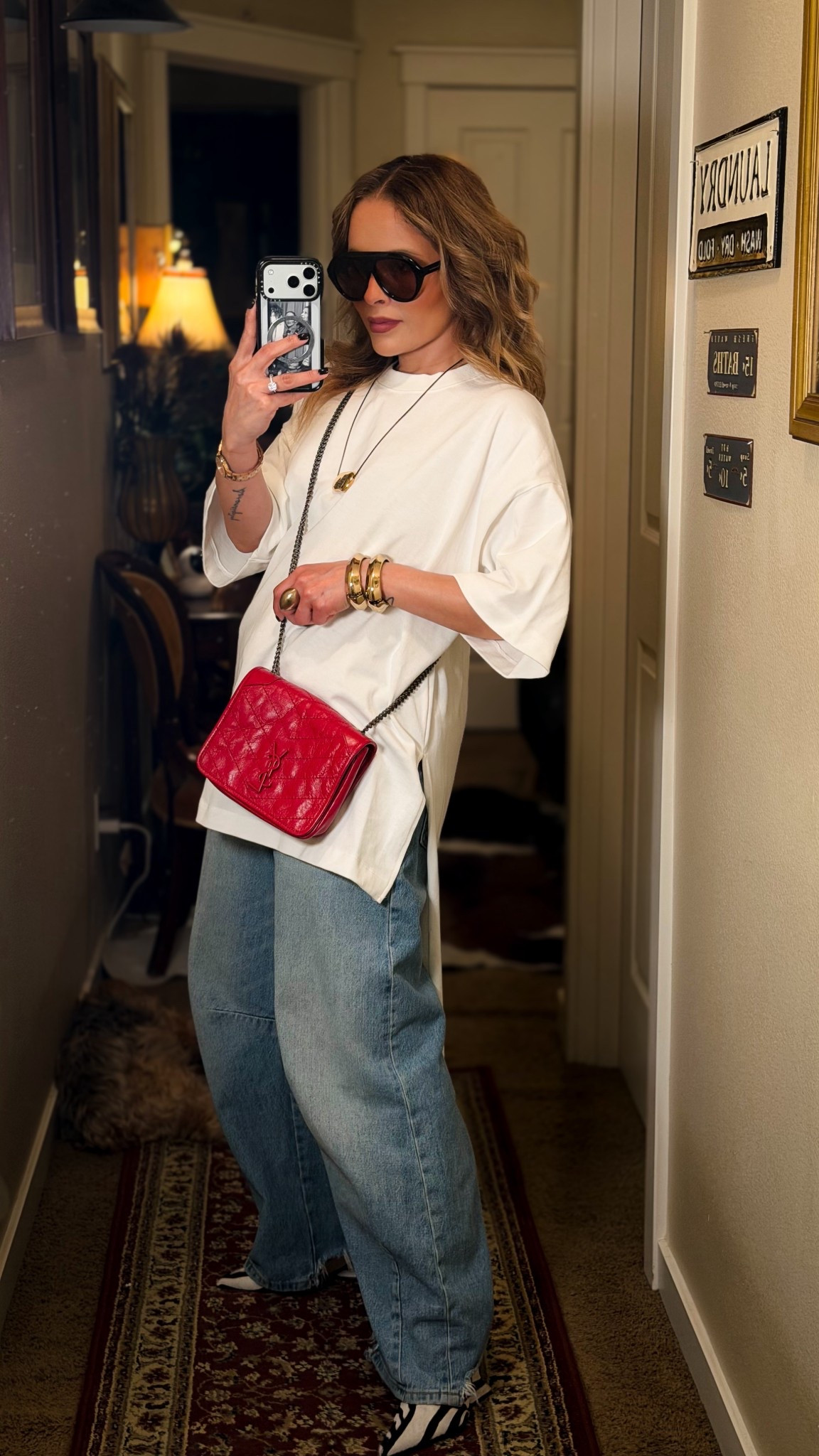 A basic is never just a basic… it’s all about how you style it.

An oversized tee and relaxed denim become instantly elevated with intentional accessories: bold sunglasses, gold jewelry, and a statement red bag that breaks the neutrality and draws the eye.

Stylist tip:
When your outfit is very simple, add one standout piece (a bag, shoes, or sunglasses). That contrast is what turns a casual look into a styled one.
