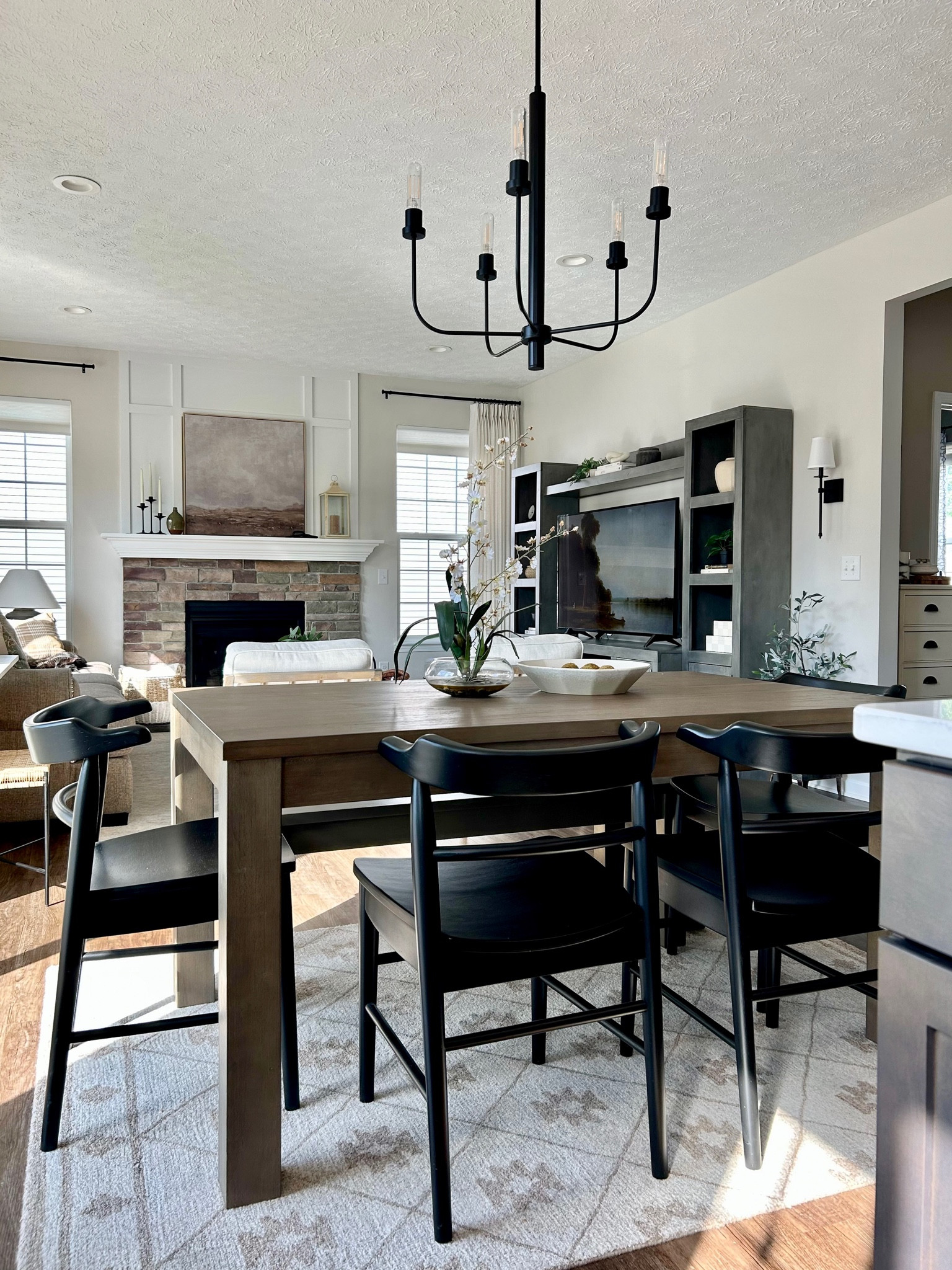 Dining room chandelier, table and chairs 
Open concept living room/dining room 
Matte black lighting, Studio McGee art, canvas art, area rug 

#LTKhome #LTKFind