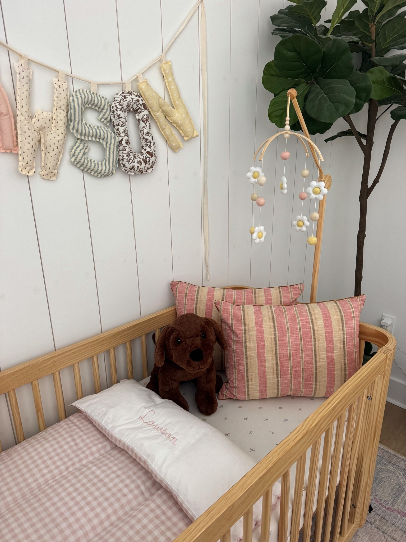 Soft vintage nursery details 🤍

Featuring the NESTIG Wave Crib, Daisy Mobile, gingham bedding, and the woven check pillow.
I love mixing warm wood tones, soft pink gingham, and delicate florals for a cozy, timeless baby room feel.

Full nursery details are also saved on my ShopMy ✨

#LTKHome #LTKmomlife #LTKBaby