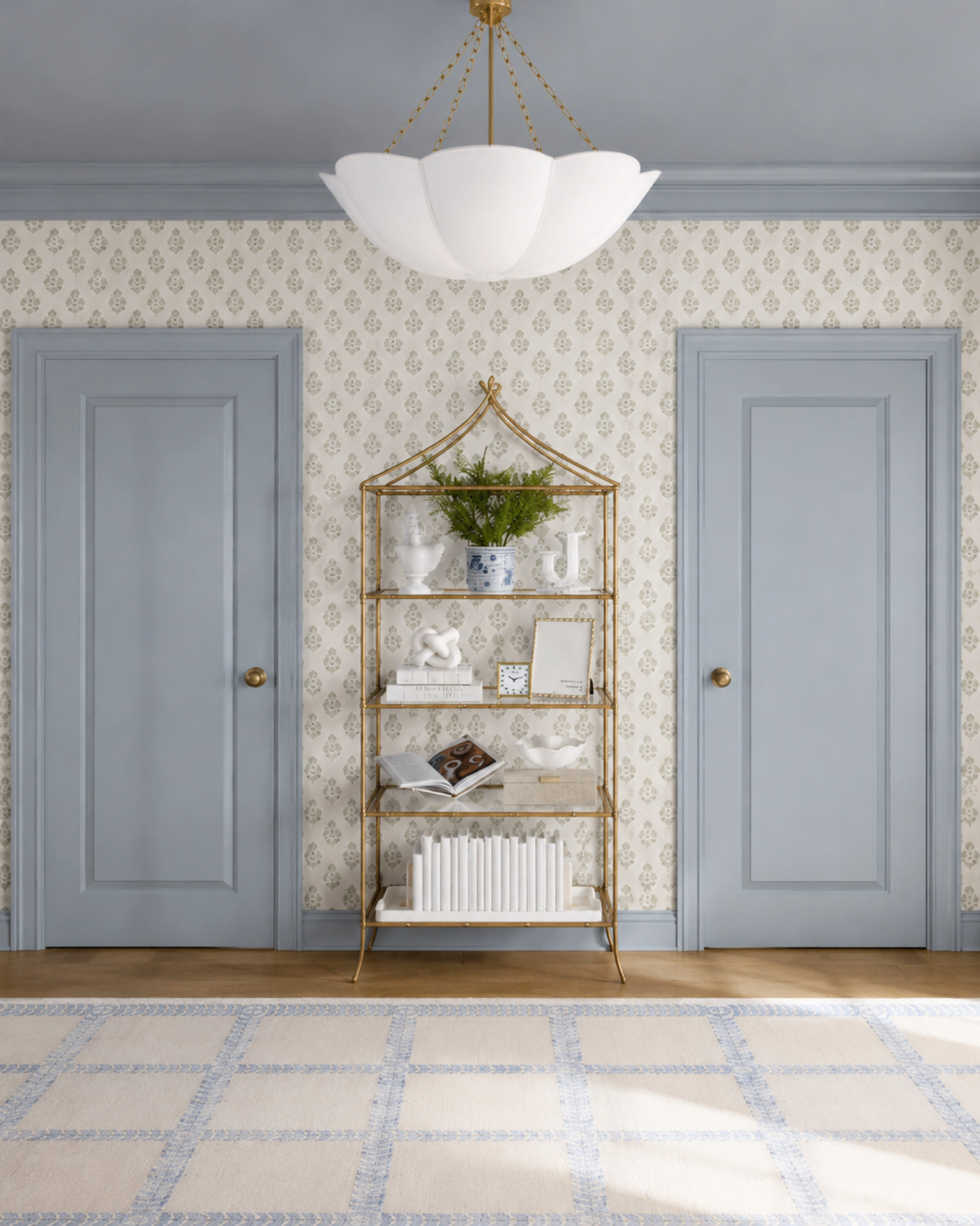 The other side of the guest bedroom keeps the same soft blue, cream, and brass palette with patterned wallpaper, blue-painted doors and trim, a brass etagere, layered decor, and a pale blue grid rug. A pretty way to make a bedroom feel finished from every angle.

I may receive a commission when you purchase through my links. 

 #LTKHome