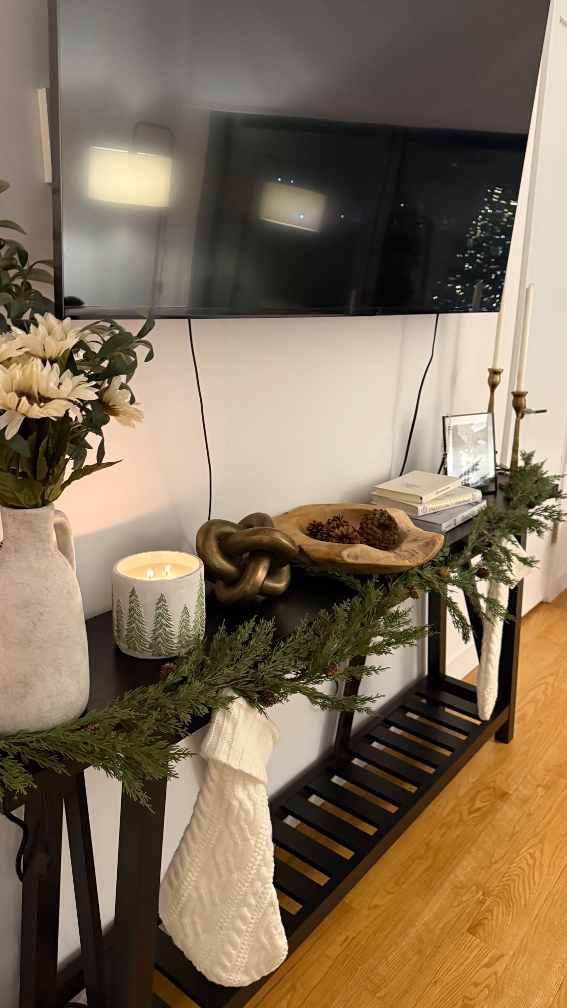 Cozy Christmas decorating ✨ My console table is finally complete — greenery garland, knit stockings, and my favorite winter candle glowing under the TV. Linking everything from the faux garland to the ceramic vase + holiday accents. Perfect neutral holiday decor for small apartments! 

#LTKHome #LTKHoliday #LTKCyberWeek