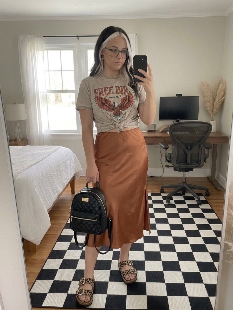 Styling a graphic tee for a chic casual look. This "Free Bird" graphic t-shirt is tied at the waist to perfectly complement a high-waisted copper satin midi skirt. It is the ultimate edgy boho outfit transition from spring to summer.

To complete the look, I paired it with leopard print double-strap sandals and a quilted black mini backpack. This outfit is perfect for brunch, a casual date night, or everyday street style.

#LTKootd #LTKSeasonal #LTKMidsize