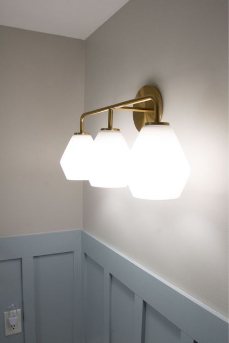 West Elm Bathroom vanity light fixture. We love the brass gold 3-light with milk geometric globes. #bathroomvanity #bathroomlight

#LTKHome