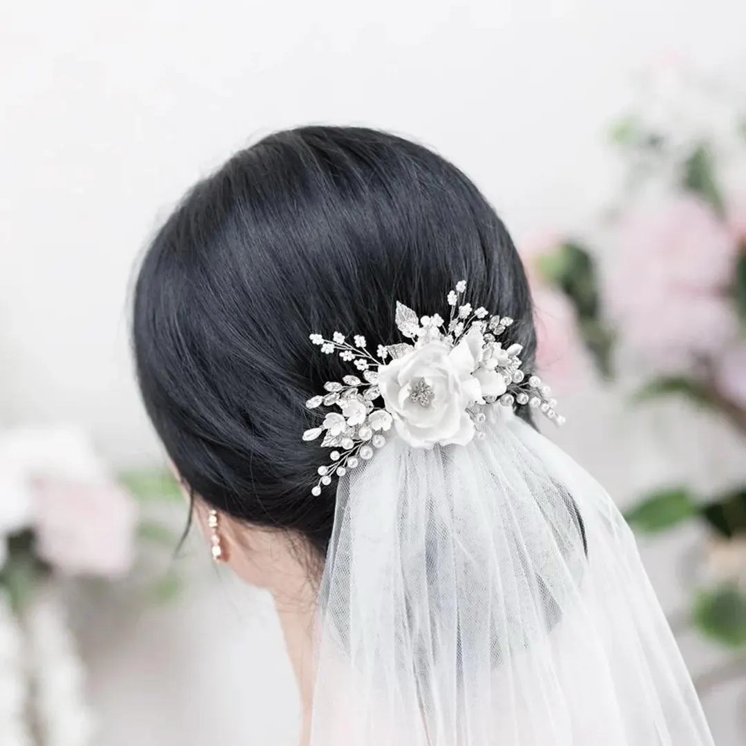 Complete your bridal look with this elegant ivory floral hair comb featuring handcrafted silk blooms, shimmering crystals, and delicate pearl accents. Designed with graceful branches and tiny handmade flowers, this piece adds soft sparkle and romantic texture to any hairstyle—from classic updos to loose waves. A timeless accessory that brings a refined, floral touch to your wedding day style. #bridalhair #ivorywedding #bridalaccessories #weddingstyle #bohowedding #ltkbride #weddinginspiration 

#LTKWedding #LTKSeasonal #LTKSpringSale
