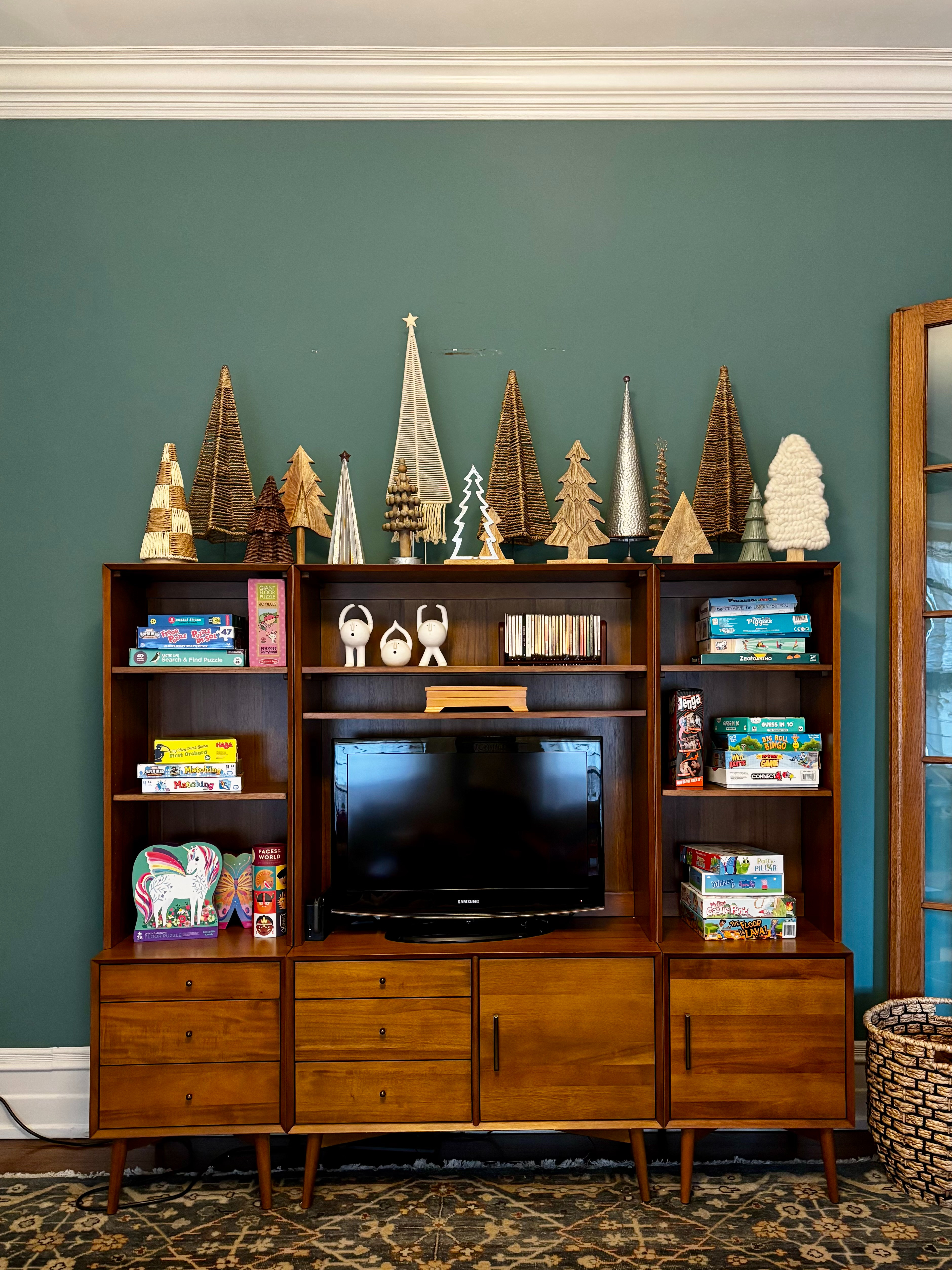 The first room off the foyer—once a traditional writing room—is now our kids’ playroom, complete with an entertainment cabinet stocked with games and puzzles. On top, we styled our growing Christmas tree collection for a playful, cheerful moment that feels perfectly festive. 🎄✨
Shop a similar look! 

 #LTKHoliday #LTKSeasonal #LTKHome