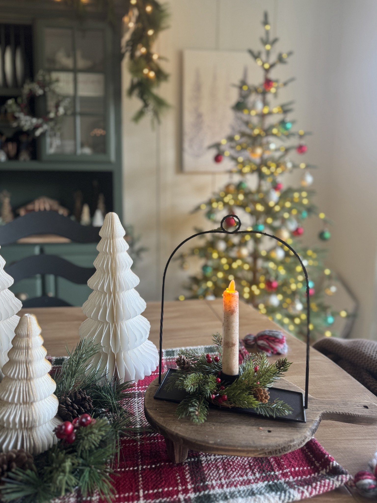 Pretty black candle holder that you can decorate for the Christmas season and then all year through. You can actually hang this candle holder if you’d like. I have a pine candle ring with red berries and pinecones with a flickering battery operated candle. White honeycomb Christmas trees. Table runner. White Christmas tree wall print. The sparse Christmas tree in the background is my favorite Balsam Hill Alpine Balsam Fir Tree with LED Clear Fairy Lights. 

#LTKHoliday #LTKHome #LTKSeasonal