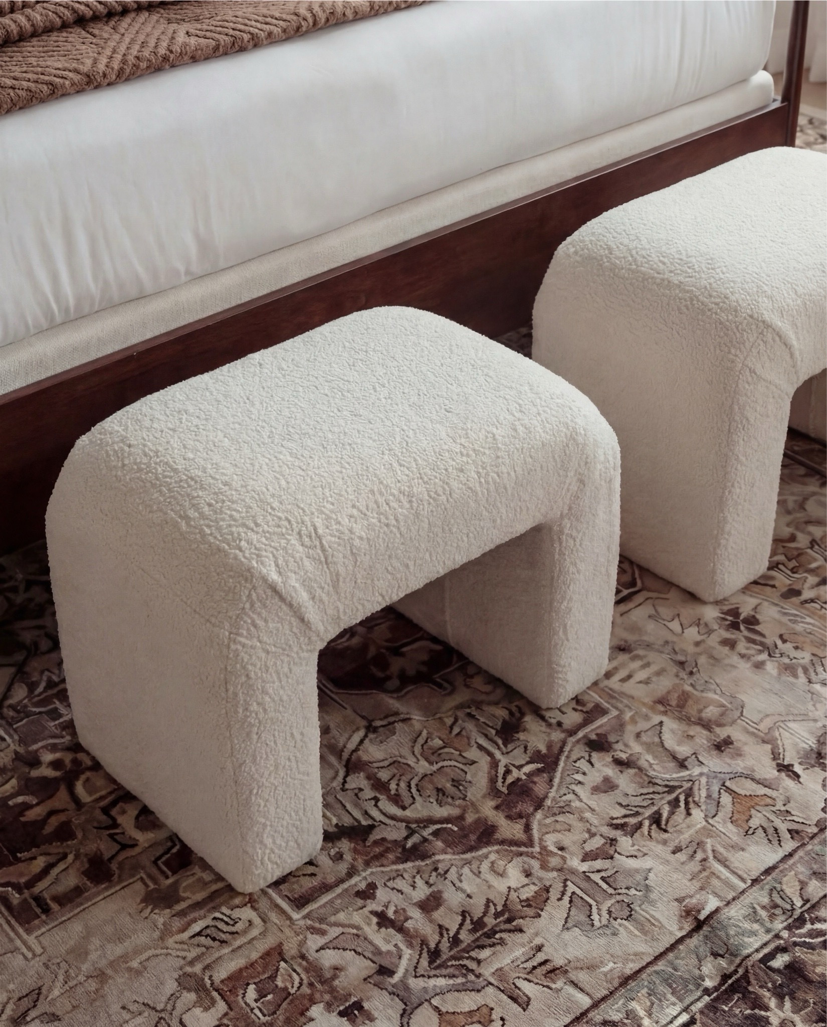 Shop the Look: Bedroom Refresh
• Dark wood bed frame with curved headboard
• Crisp white bedding set (duvet + sheets)
• Warm brown accent pillows
• Textured knit or woven throw blanket (camel/brown)
• Ivory boucle bench stools (set of two)
• Vintage-style patterned area rug (neutral brown + taupe tones)
• Wood nightstands with drawers
• Table lamps with white drum shades
• Wall sconces with brass detail
• Framed landscape artwork above bed
• Organic-shaped wall mirrors (brass frame)
• Black fluted dresser with brass hardware
• Round brass wall mirror
• Sculptural white ceramic bowl
• Decorative books with wood bead garland
• Neutral ceramic vase with dried branches
• Upholstered accent chair (cream fabric, wood frame)
• Slim brass floor lamp with white shade



#LTKHome #LTKSaleAlert