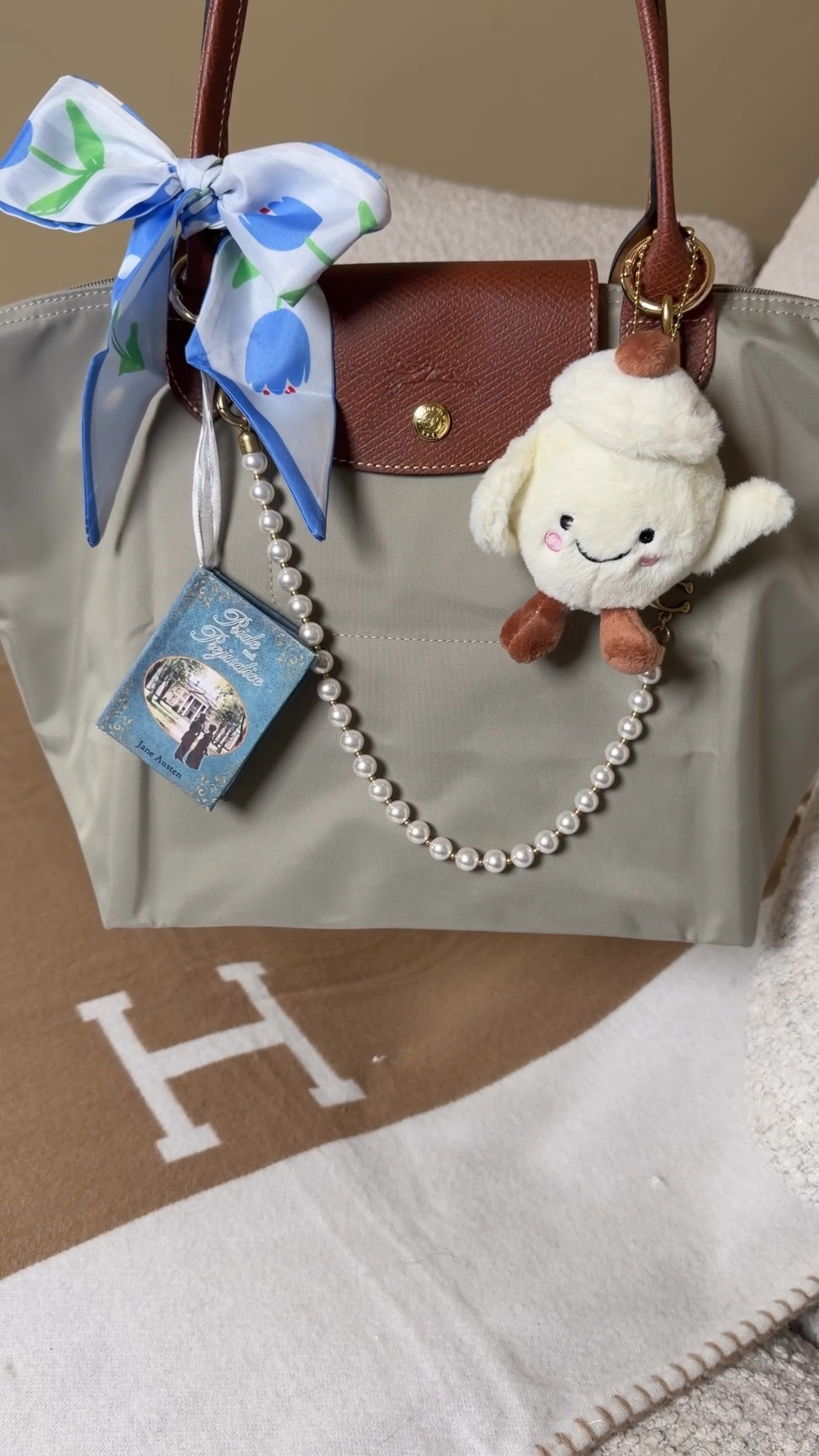 How to style a gray Longchamp Le Pliage 🩶 Comment SHOP & I’ll dm you the links 🩶

This is the medium Longchamp Le Pliage shoulder bag in the color pebble. I added a bag insert for some structure and organization.

Spring inspired Longchamp packing:
Mini coin pouch, Gisou honey lip oil, rose anise french mints, pink light up compact mirror, croissant claw clip, floral kindle cover.

Bag styling for spring: coach pearl strap extender / chain, pride and prejudice book charm, tea pot bag charm (TT shop) and floral Twilly 

What’s in my bag, what fits in a medium Longchamp 

#LTKdayinmylife #LTKgrwm #LTKootd