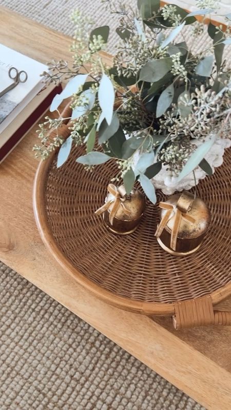 A coffee table styling idea for Christmas!  A basket tray with a vase and brass bells, coffee table books stacked with a candle & accessories  

#LTKhome #LTKHoliday #LTKfindsunder50
