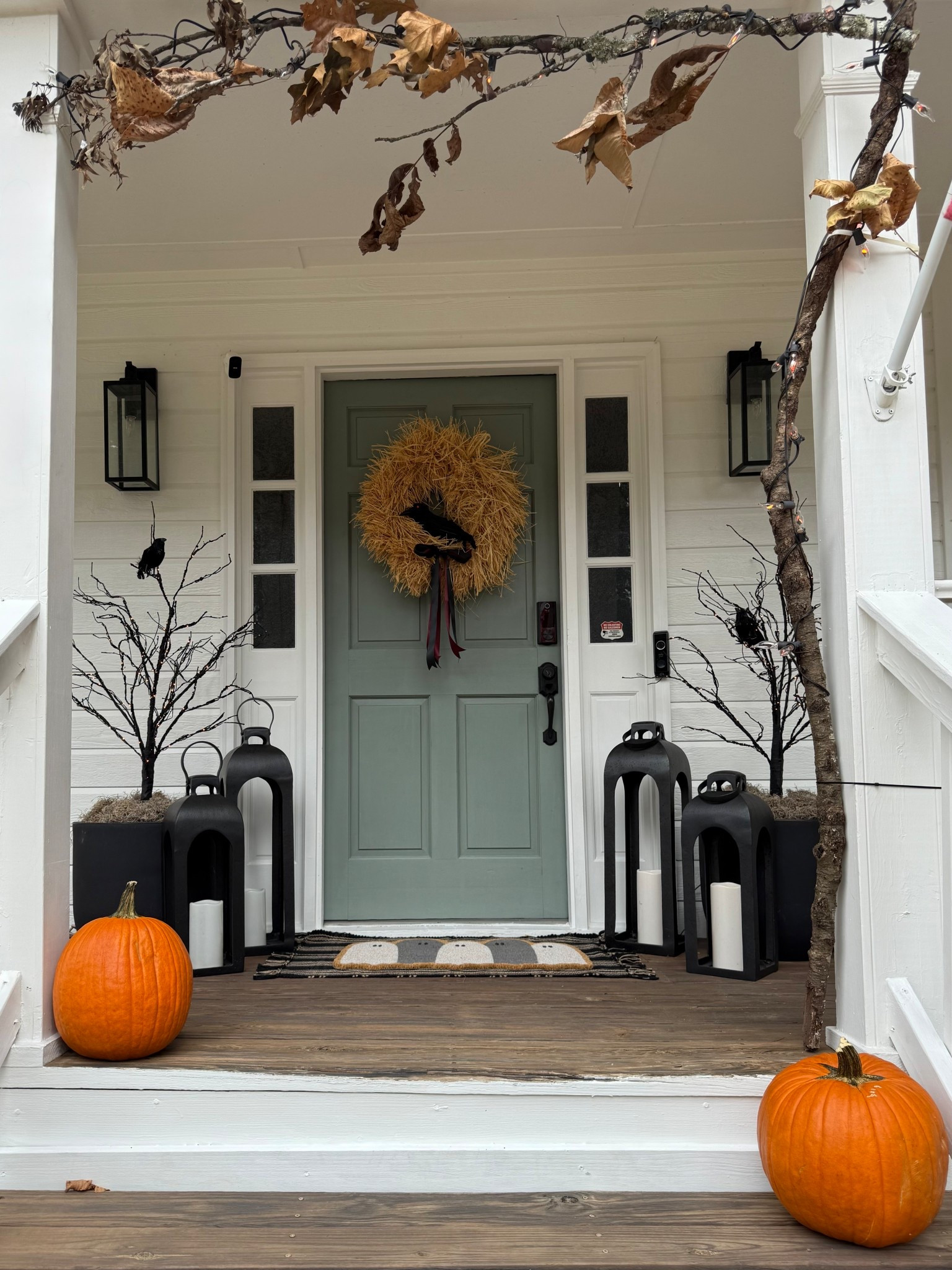 Halloween Porch:

Prelit 4ft trees
Lanterns 
DIY straw wreath with satin ribbon
Crows 
Pumpkins 
Flickering lights 

*Tree branches and leaves from my yard zip tied to my column to create the arch over the porch entry

#LTKHalloween #LTKHome #LTKSeasonal