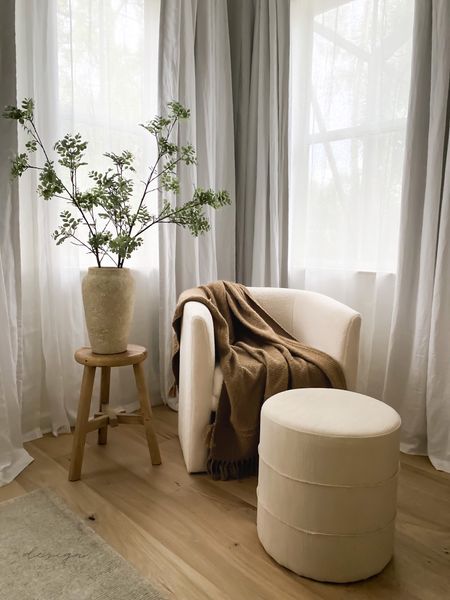 Bedroom reading corner sitting area, armchair, round ottoman stool, vintage reclaimed side table, vase, faux stems, linen curtains,  neutral rug, warm neutral decor 

#LTKhome