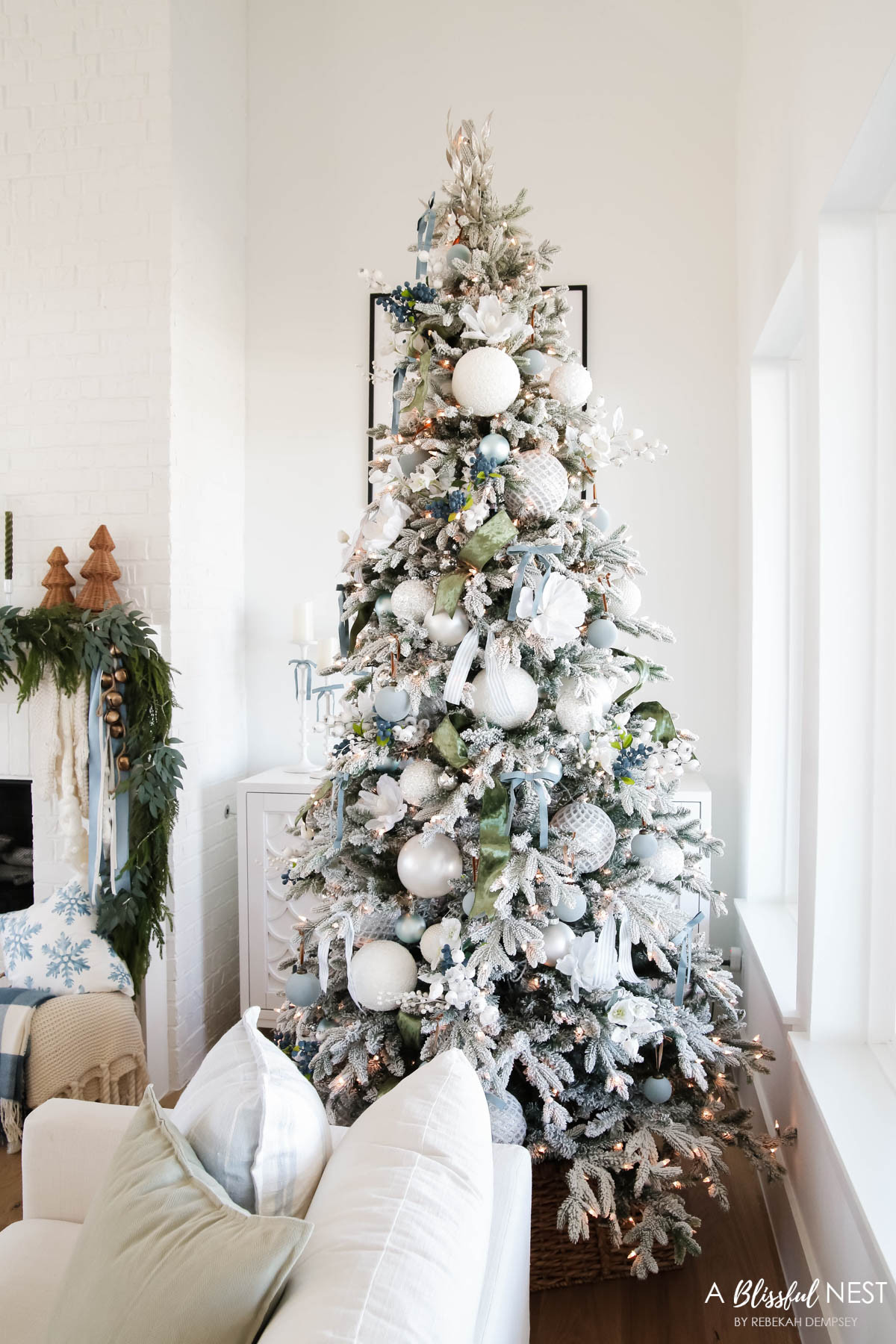 My frosted tree look from last year was one of my all time favorites with those soft layers and pretty blue touches. Shop the look today.
blue velvet bows, knit Christmas stockings, woven Christmas cone tree, Norfolk pine Christmas garland, olive green taper candles, candlestick holders, dusty blue satin ribbon, ivory velvet ribbon, vintage cluster cow bells on rope, snowflakes pillow, fairy lights, baby blue matte Christmas ornaments, artificial blueberry picks, velvet Christmas balls, green velvet ribbon, blue paid throw blanket, cube ottoman, cream sofa, snowflakes pillow 

 #LTKHoliday #LTKSeasonal #LTKHome