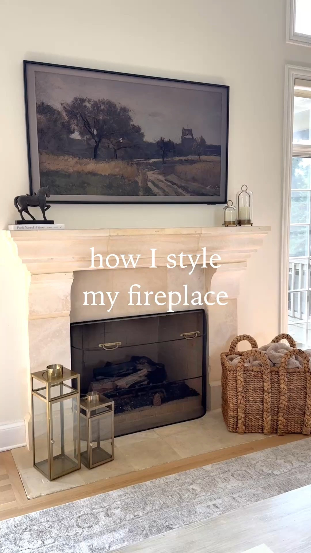 How I like to style my fireplace 🫶🏼 I like to keep it rather simple and symmetrical for the most part. A giant woven basket at the bottom that houses our throw blankets, two lanterns I got years ago, some candle holders with rechargeable candles, a decorative object on top! Everything is angled inwards with larger items on the edge and smaller ones toward center to draw your attention to the focal point of the fireplace/TV ☺️

#LTKHome