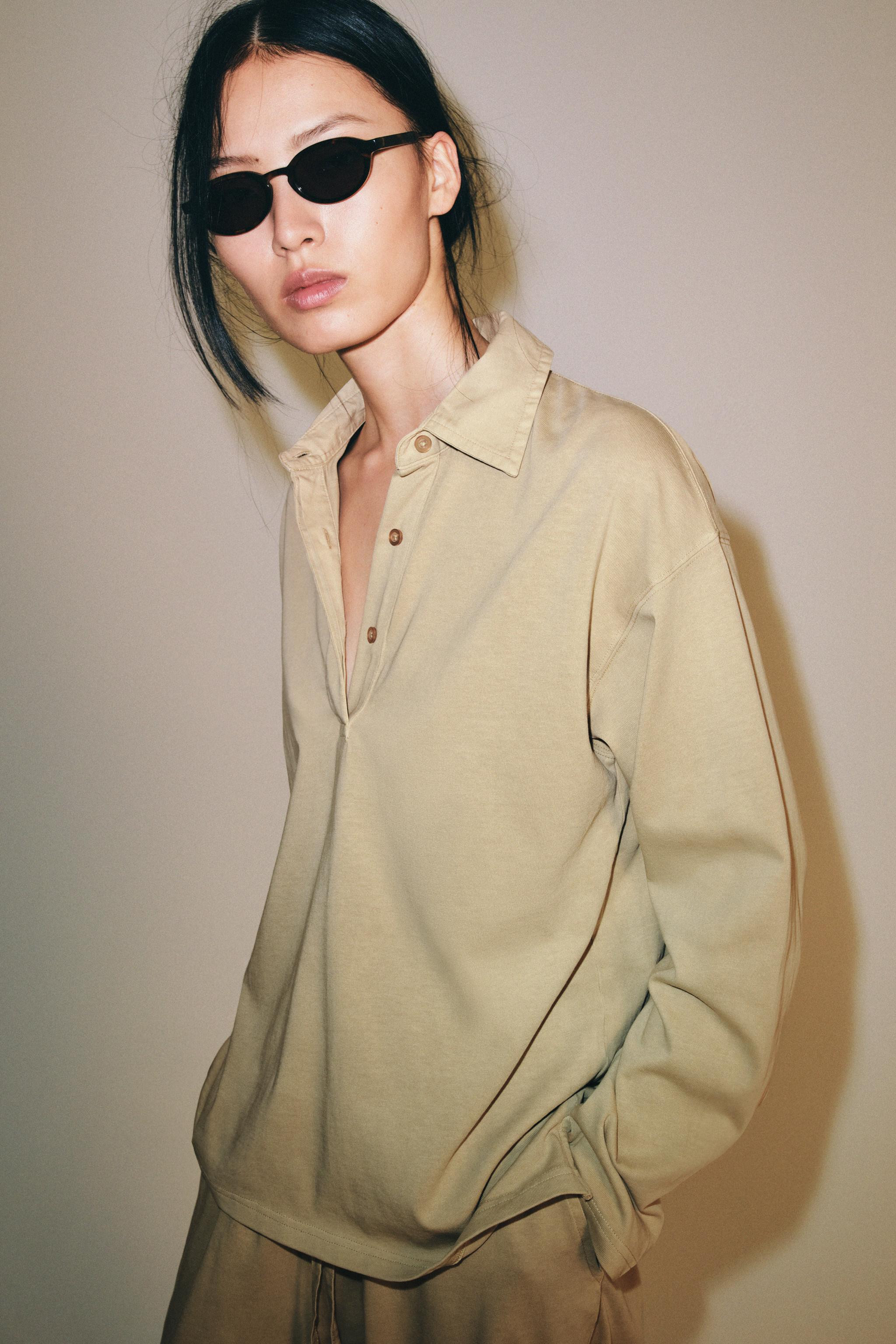 Oversized polo shirt crafted from 100% cotton yarn. Features a polo collar, long sleeves, and fro... | Zara US