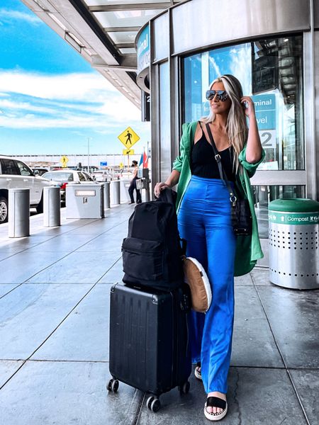 Airport look. Travel outfit. Travel style inspiration. Basic black blouse. Green blazer. Green blouse. Green top. Carry-on. Wide leg pants. Blue pants. Black shoes. Black crossbody bag. Sunglasses. Airport look. Travel look. Black backpack. Black luggage. #fashioninspiration #stylingideas #airport #travellook #airportfashion #bluepants #greentop #backpack

#LTKtravel #LTKfit #LTKstyletip