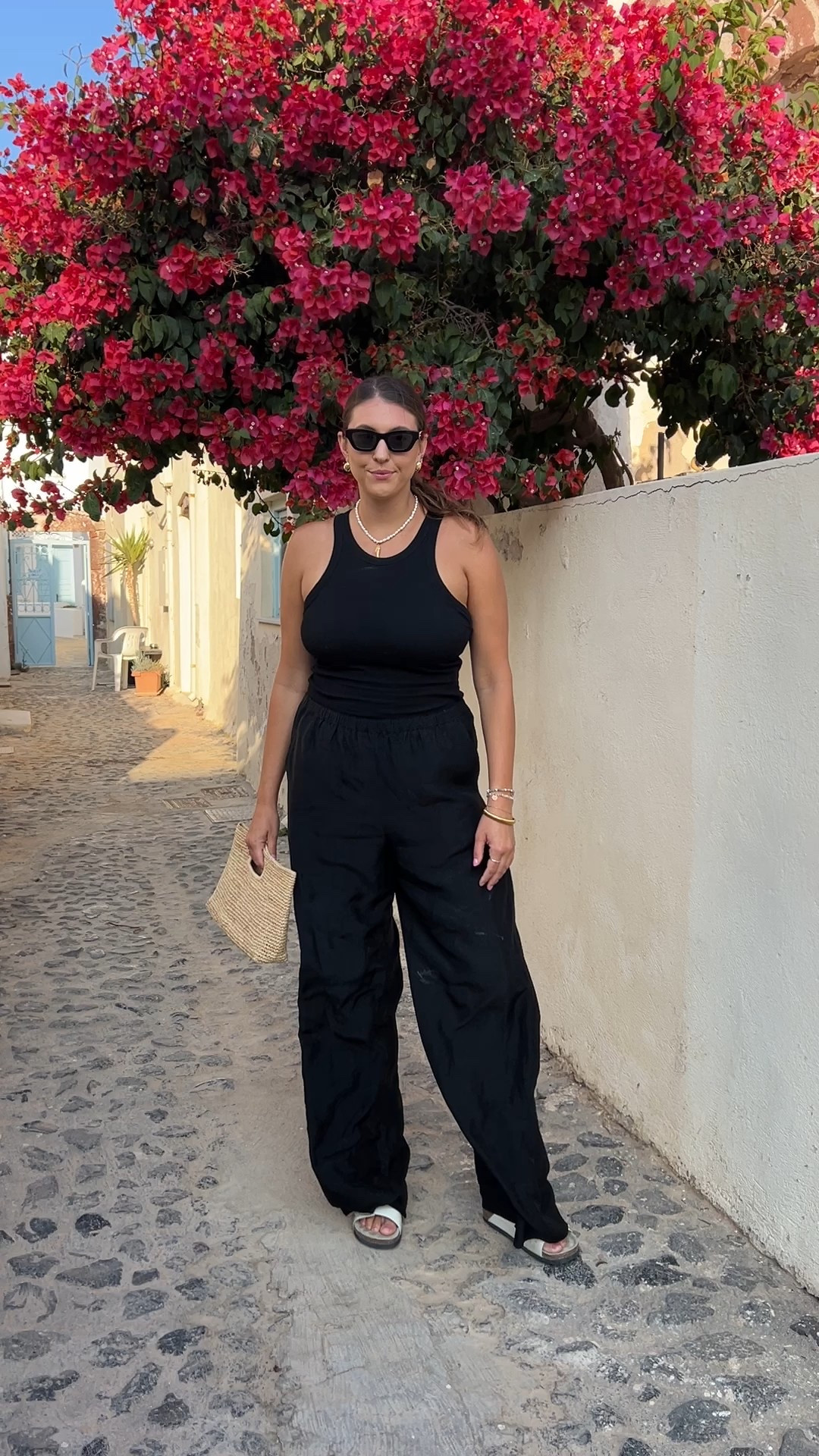 This is one of those travel outfits that looks elevated but feels so comfortable. A simple black tank with flowy black pants is my go-to for walking around all day, sightseeing, and stopping for dinner without needing an outfit change. Lightweight, breathable, and easy to style with neutral sandals and a woven clutch — classic, chic, and timeless.

Keywords: black summer outfit, black tank outfit, black pants outfit, Italy vacation outfit, European summer outfit, Amalfi Coast outfit, Positano outfit inspiration, travel outfit for Europe, comfortable travel outfit, minimalist summer outfit, chic sightseeing outfit, lightweight summer pants, elevated basics outfit, vacation capsule wardrobe, neutral summer accessories, woven clutch outfit, black resort wear, effortless summer style, walking outfit for travel, timeless summer outfit

#LTKgrwm #LTKTravel #LTKMidsize