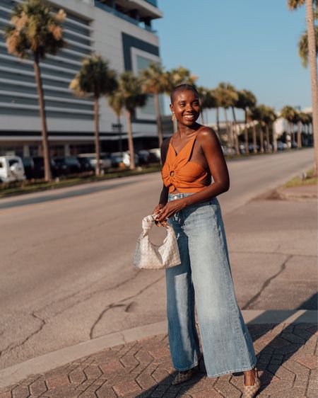 Summer outfit! Rachel flower tie back top from Cult Gaia, wide leg high rise jeans, gold flower earrings from Sezane, cream knotted purse and Gucci sling back heels  