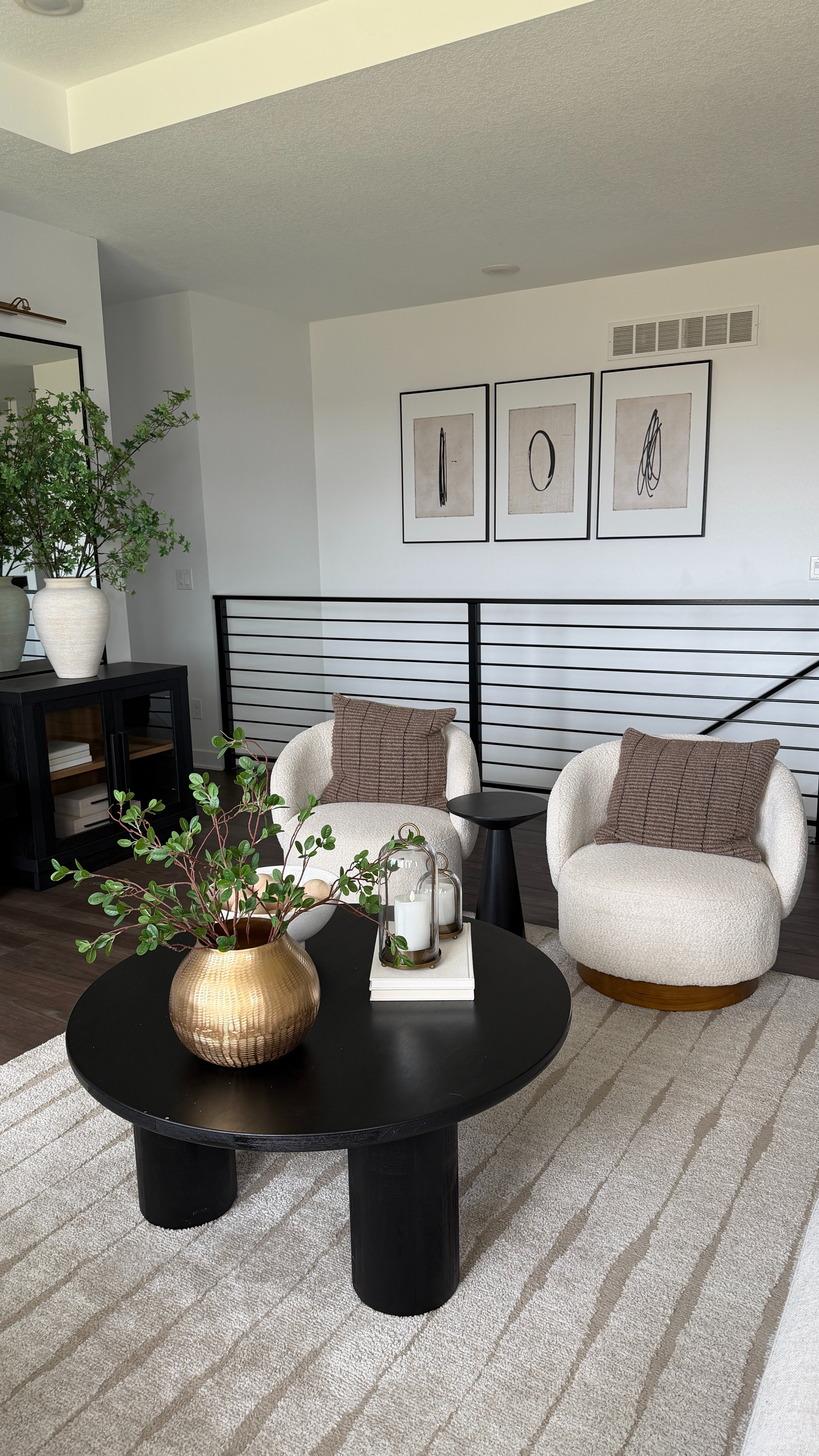 My living room coffee table and rug are so loved 🤍 Such a good combo that really sets the vibe, especially with the swivel chairs, 3-piece art, and vases with stems layered around the space. 

 