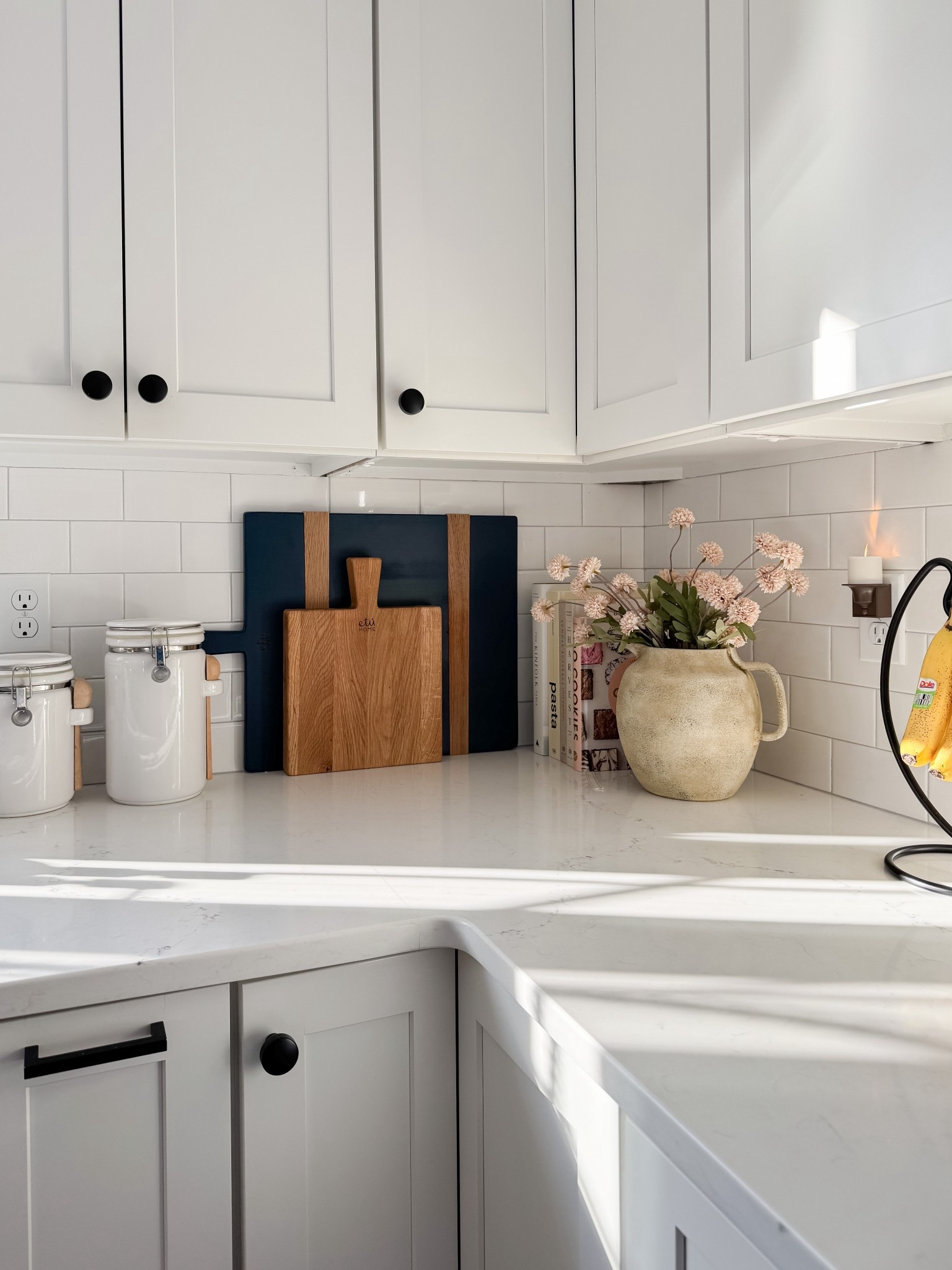 Kitchen counter styling with textured ceramic pitcher vase, soft blush florals, stacked cookbooks, and white subway tile backsplash. Warm neutral kitchen decor for a simple seasonal refresh. 
kitchen counter decor, ceramic pitcher vase, spring kitchen decor, cookbooks styling, subway tile kitchen, neutral kitchen, blush florals, kitchen styling ideas, coastal kitchen decor, simple home refresh, cottage kitchen, everyday decor, sherri calnan home

#LTKHome