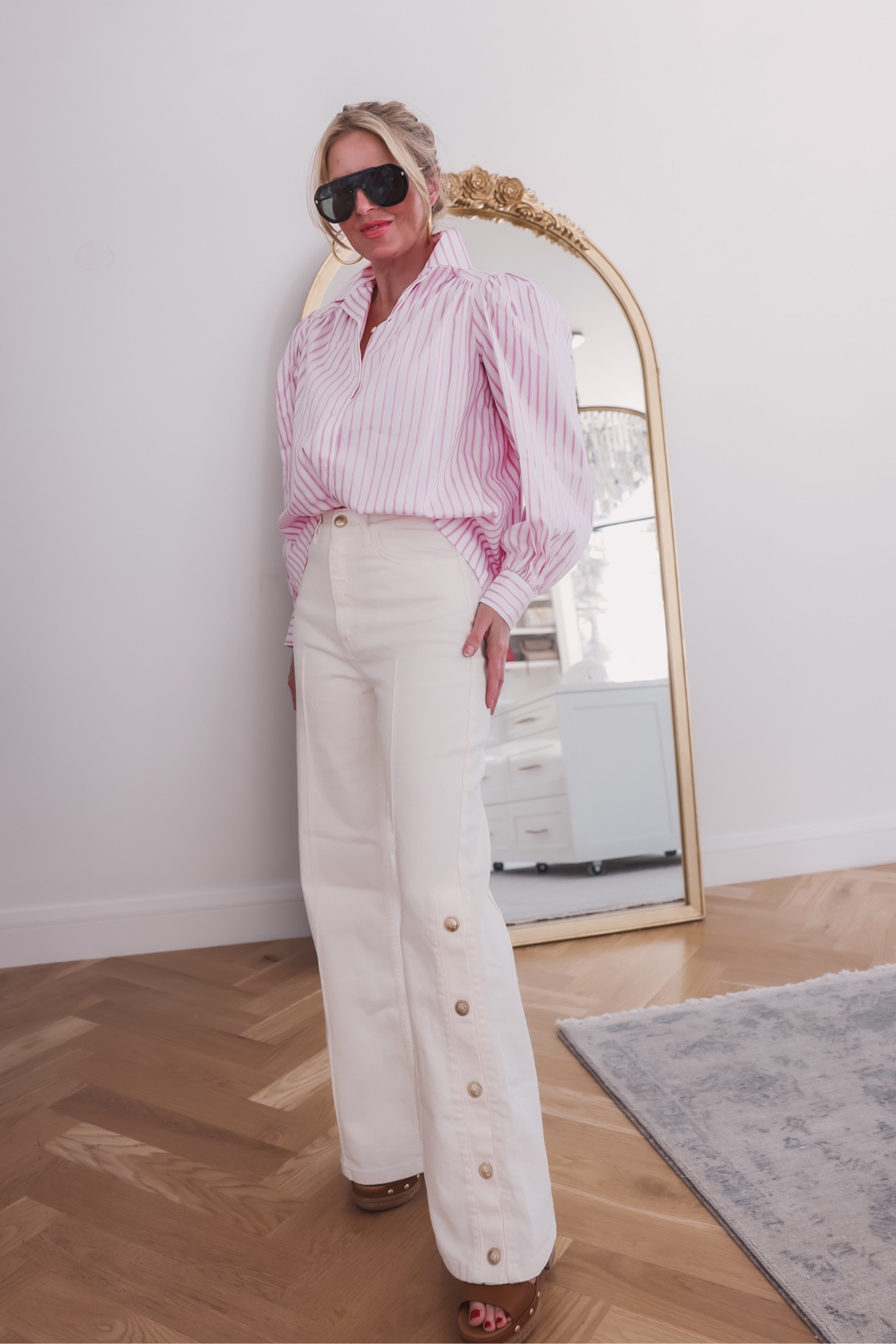 These beautiful wardrobe basics are perfect to wear casually or to the office. The wide-leg pants are super on-trend, flattering, and versatile. I LOVE the button detailing down the sides. It's such a chic detail that really elevates the pants. (Fit is true to size.) I paired them with a really beautiful pink striped blouse. This blouse is a standout piece because of its fit and details. It's oversized, which is very on-trend right now, and it has a really unique cut at the shoulder complete with feminine puff sleeves. It's also very lightweight, offering coverage but allowing you to stay cool. (Also true to size.)

With this outfit, I'm wearing a gorgeous pair of platform heels. I love the gold stud and buckle strap details on these. They're also very comfortable to walk in (for heels). And lastly, I added my favorite new aviator sunglasses and a pair of modern gold hoop earrings. These earrings are some of my go-to's, because they are easy to style up and down and they're super lightweight (no pulling down on your earlobe).

~Erin xo

#LTKworkwear #LTKstyletip #LTKSeasonal