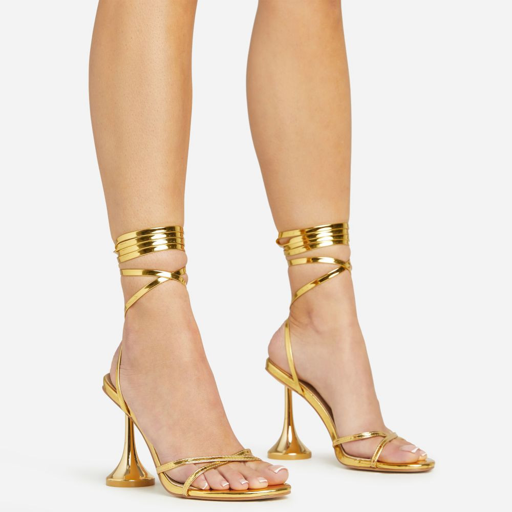 Sylvie Lace Up Cross Strap Detail Gold Statement Heel In Gold Faux Leather | EGO (UK)