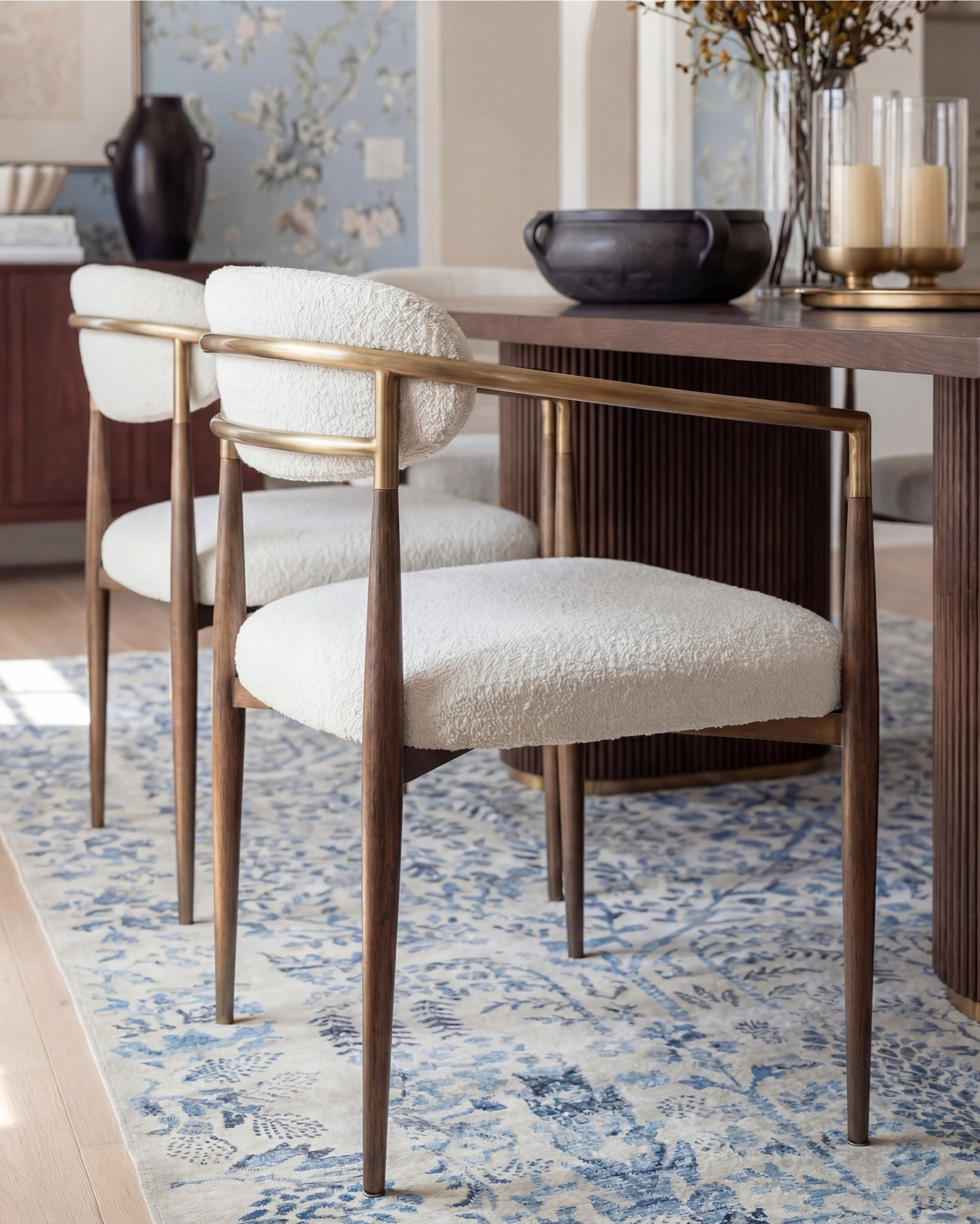 This dining room feels like a pause in time—in the best way. The soft blue floral wallpaper instantly sets the mood, while the exposed wood beams ground the space and keep it from feeling too formal. It’s classic, but approachable.

What really makes this room work is the balance: the sculptural wood dining table anchors everything, while the light, upholstered chairs keep it airy and inviting. Brass accents add just enough warmth, and that blue patterned rug quietly ties the walls to the floor without competing for attention.

It’s elegant, intentional, and designed for long dinners that turn into even longer conversations.

Shop the Look:
• Solid wood dining table
• Upholstered dining chairs with brass frames
• Blue floral wallpaper
• Blue patterned traditional rug
• Wood ceiling beams
• Glass candle holders
• Black ceramic bowl decor
• Black ceramic vase
• Brass serving tray
• Solid wood buffet console
• Solid oak tall cabinet
• Black ceramic decor bowl
• White decor books
• Black table lamp, white fluted decor bowl
• Neutral linen curtains
• Wood display cabinet with glass doors

#LTKhome #LTKsale #LTKstyletip