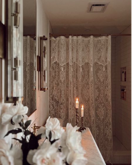 One of my favorite simple luxuries is showering by candlelight.

Did you know candlelight is proven to reduce cortisol levels?

Lace shower curtain, brass art deco sconces, faux florals, luxe bathroom, dark bathroom vanity, extra tall bathroom mirror, brass mirror fixtures, classic white tile

#LTKfamily #LTKhome #LTKfindsunder100
