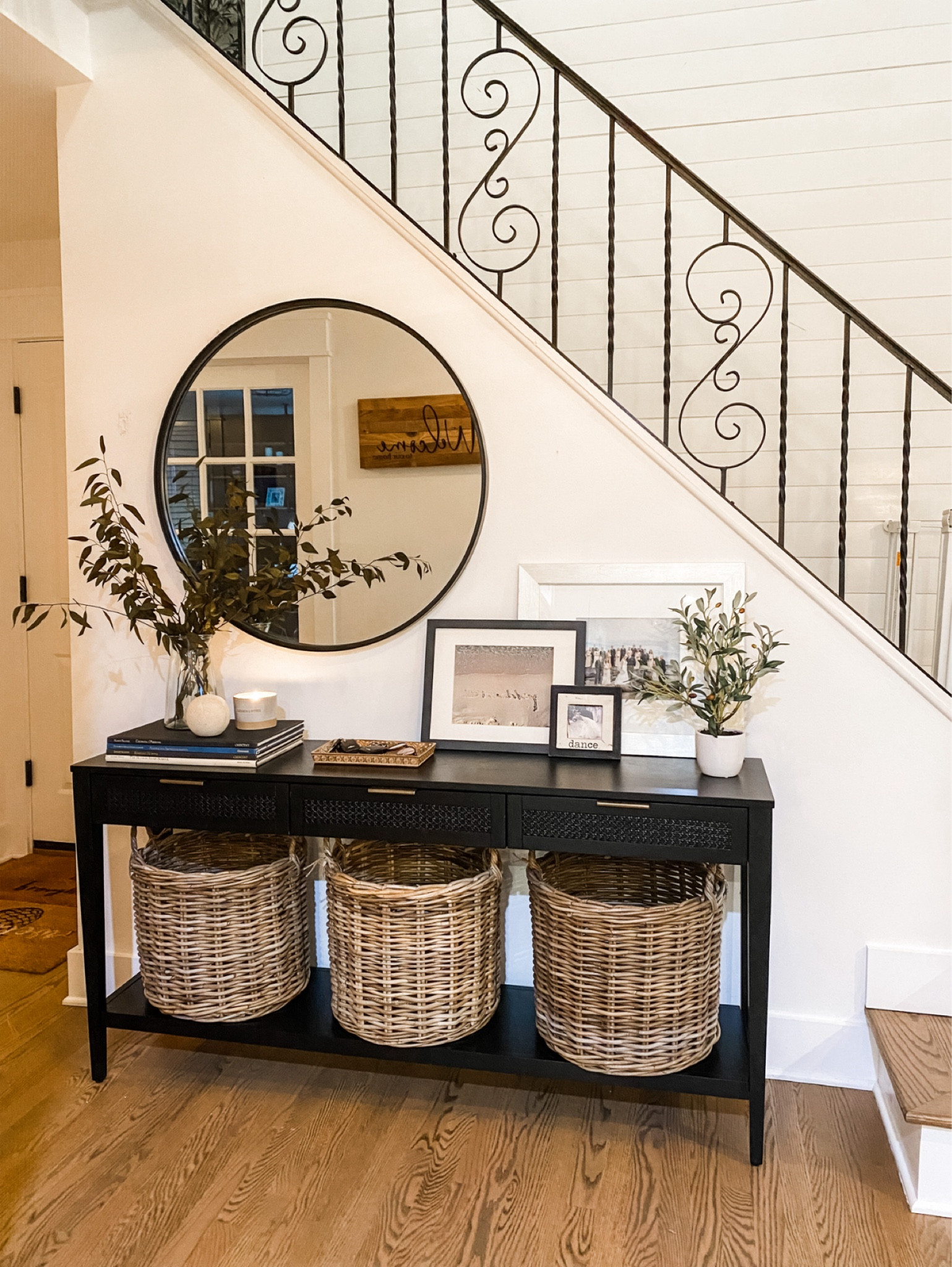 Studio McGee Black console table for our foyer! Filled with 3 baskets and balanced out with a round wall mirror and some photographs for a personal touch. Add touches of faux greenery for texture and dimension  

#LTKunder100 #LTKhome #LTKunder50

#LTKFindsUnder100 #LTKHome #LTKSummerSales