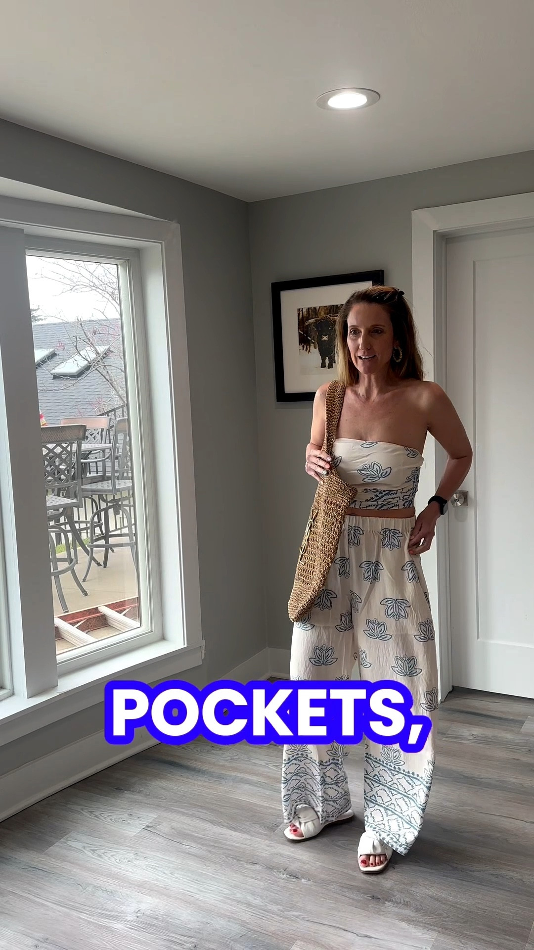 Embracing breezy silhouettes and coastal patterns for the new season. 🐚👖 Pairing a cropped bandeau with high-waisted, printed pants creates such a sophisticated, elongated frame. You can grab the direct link for this entire ensemble and more of my travel favorites in my bio! 💫 #OOTD #CoastalStyle #SummerBasics #LTKfinds @VICI 

My Resort Ready Style Breakdown
• The Set: I’m wearing a matching two-piece set in a cream fabric featuring a blue Mediterranean-inspired tile and floral print.
• The Top: The top is a strapless bandeau style that is cropped to meet the high waistline of the trousers.
• The Pants: The trousers feature a relaxed, wide-leg fit with an elasticized waistband and functional side pockets.
• The Accessories: I’ve styled the look with a large woven straw shoulder bag and chunky gold hoop earrings to lean into the vacation aesthetic.
• The Vibe: This ensemble is the definition of "effortless resort"—it’s light, breathable, and perfectly curated for a beach destination or a sunny brunch.

cream and blue matching set, strapless bandeau top, wide leg printed pants, tile print trousers, woven straw bag, gold hoop earrings, resort wear outfit, vacation style, coastal grandmother aesthetic, breezy summer set, LTKstyle

#LTKootd #LTKOver40 #LTKTravel