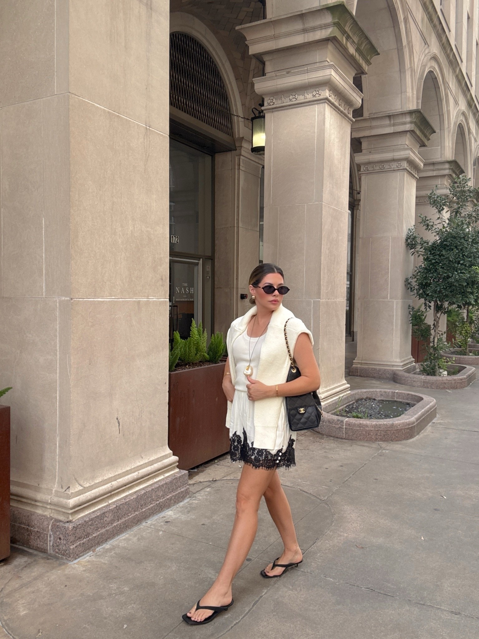 Summer neutral outfit 🤍 Wearing the prettiest cream knit tank with lace trim shorts, a draped sweater, black Chanel flap bag, flip flops, statement pearl necklace, and cat eye sunglasses. The perfect elevated casual summer outfit for vacation, brunch, date night, Europe travel, or everyday chic style. Everything is linked in my LTK! #LTKStyle #NeutralStyle #SummerOutfit