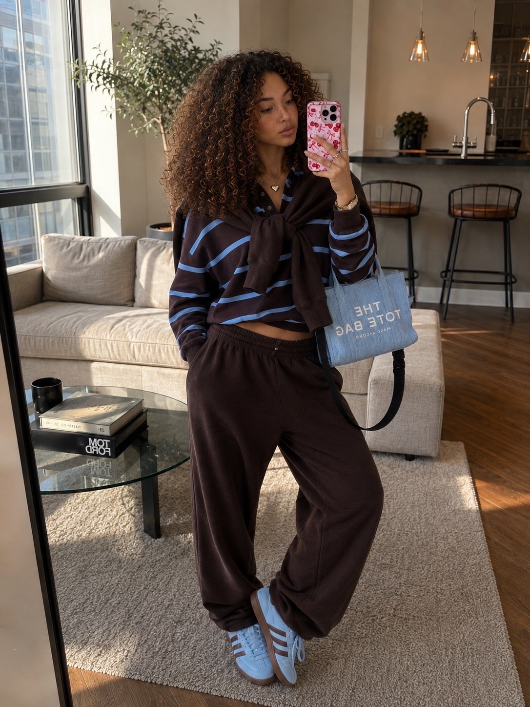 Brown & Blue Cozy Everyday Outfit 🤎🩵

This is one of those outfits that looks effortlessly put together while feeling like you’re wearing loungewear. 🤎 The brown striped rugby top paired with matching oversized sweatpants gives the perfect relaxed fit, while the light blue Adidas Handball Spezial sneakers and blue Marc Jacobs tote add the prettiest pop of color. Whether you’re heading out for coffee, running errands, traveling, or working from your favorite café, this look is equal parts comfy and cute.

Wearing size S.

Linked:
🤎 Brown striped rugby top
🤎 Matching oversized sweatpants
🩵 Adidas Handball Spezial sneakers (Light Blue/Brown)
🩵 Marc Jacobs “The Tote Bag” Mini (Blue Shadow)
🍒 Cherry phone case