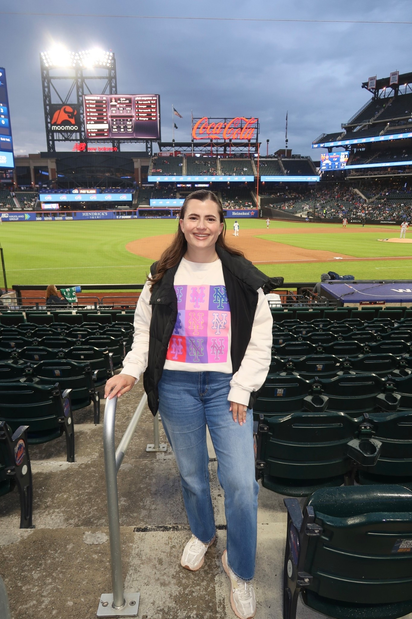 Baseball game outfit idea! What I wore to the Mets game at Citi field. Terez makes great MLB team sweatshirts and other athleisure. I wore my LOFT Rivete jeans and my Nike sneakers with a puffer vest for extra warmth  