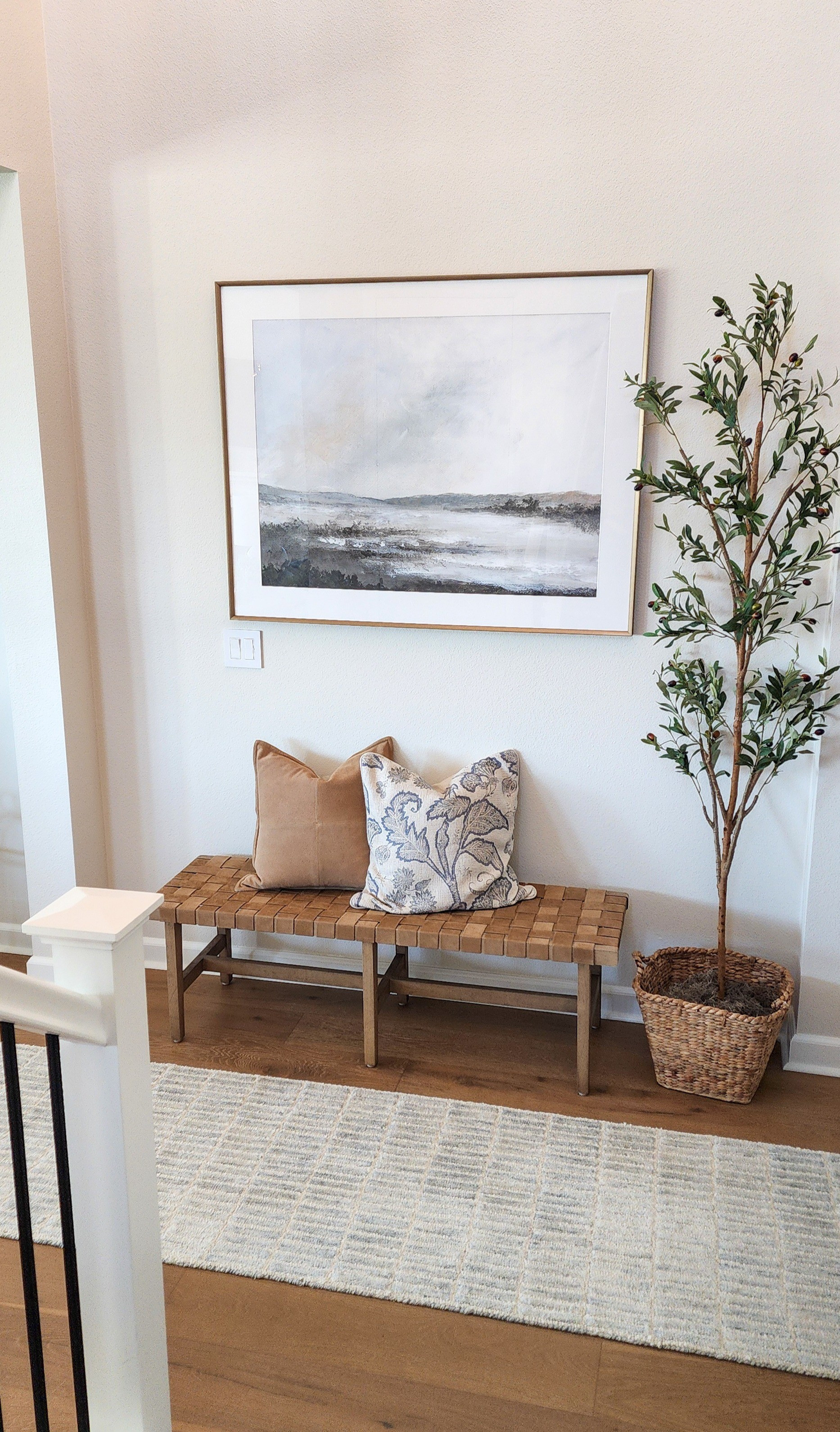 Coastal style Entryway with beautiful textured pillows, one of my favorite runner rugs, a sueded leather strapped bench, coastal artwork and a simple slender olive tree. 

#LTKHome