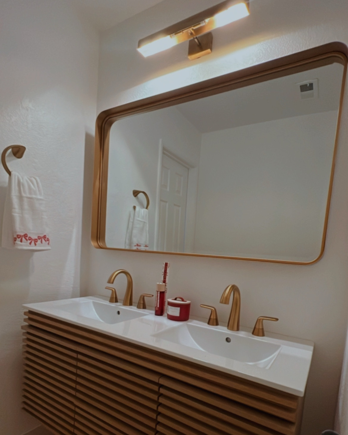 Elevate your bathroom style with this modern double vanity setup! Featuring sleek gold-tone faucets and a matching framed mirror, this design brings a warm, contemporary vibe to your space. The vanity combines clean lines with a natural wood finish, adding texture and sophistication. Perfectly paired with functional lighting and subtle decor, it's the ideal blend of luxury and practicality.
#home
#homeimprovement
#diyhome
#goldbathroom

#LTKStyleTip #LTKHome #LTKFamily