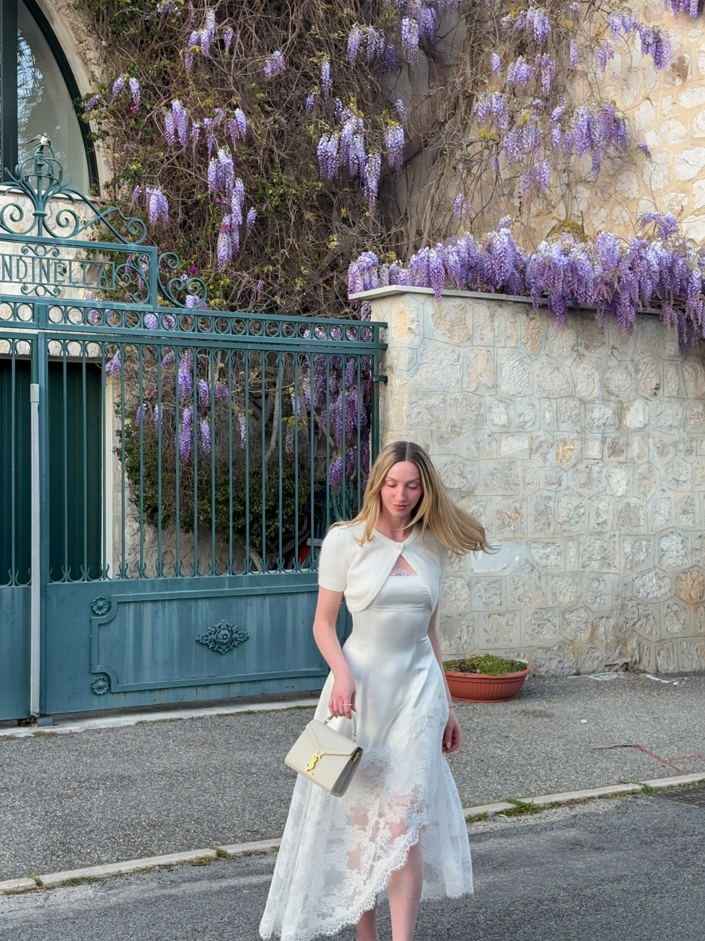 Outside without a coat!🪻 @nanajacqueline_ 

🏷️: #justagirl #wisteriahysteria #springoutfitinspo spring is here, wisteria blooms, south of france, French Riviera aesthetic, white lace midi dress, Nana Jacqueline, spring outfit inspiration, springtime outfit ideas, prettiest French towns, Menton