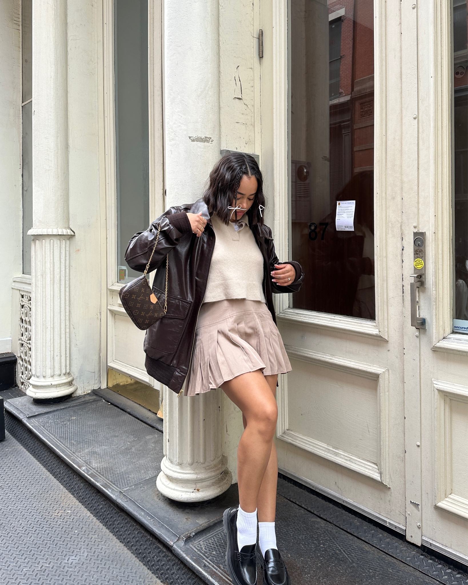 nyc preppy outfit | school girl brown skirt, beige cashmere sweater, brown oversized faux leather jacket , vintage louis vuitton bag and black loafers 

#LTKFind #LTKtravel #LTKfit