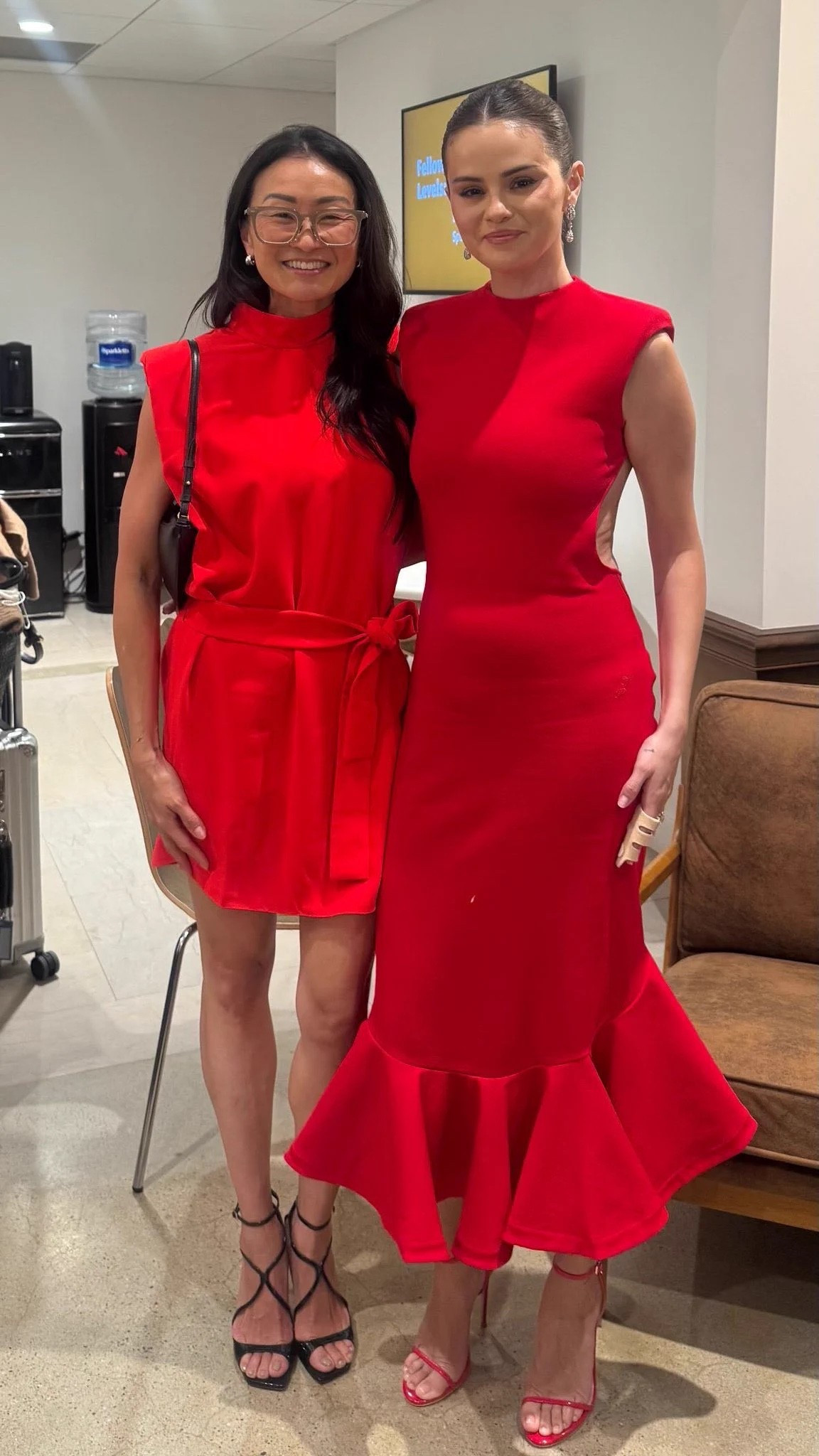 Selena Gomez red dress captures a distinctively modern allure through its masterful approach to bold silhouettes and daring proportions. The Palmier cocktail dress features structured shoulder pads, a dramatic open back, and an asymmetric fluted hemline.