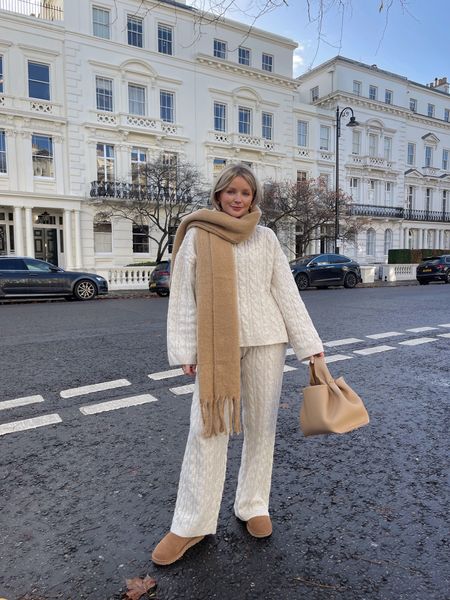 Cosy chic loungewear, perfect for dressing up in winter. Cable knit cream jumper and trousers (similar linked), brown chunky knit scarf, brown polene paris bag (alternatives linked) & Ugg boots. 

#LTKeurope #LTKstyletip #LTKSeasonal