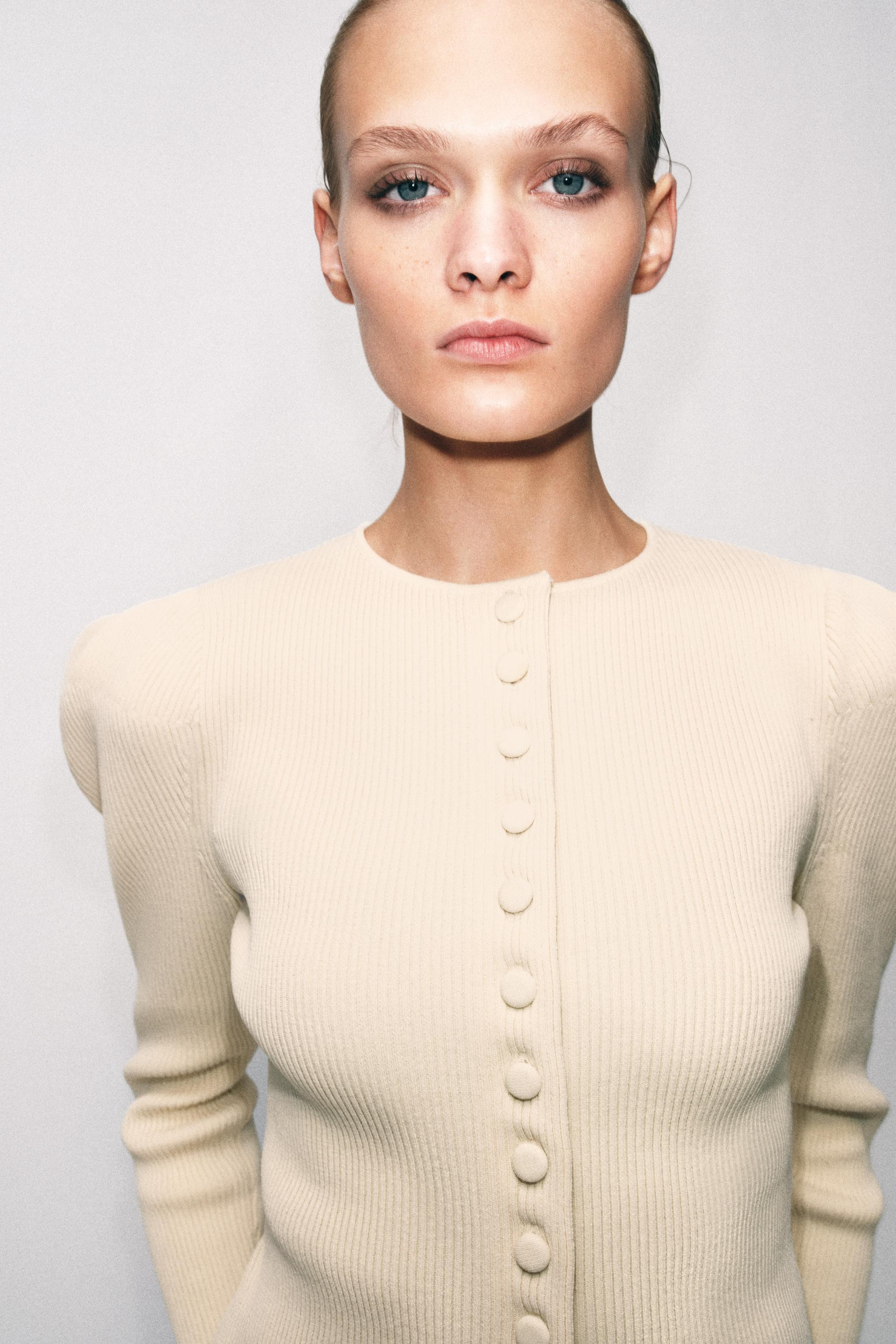 Round neck cardigan with puff sleeves and an asymmetrical finish. Front fastening with covered bu... | Zara FR