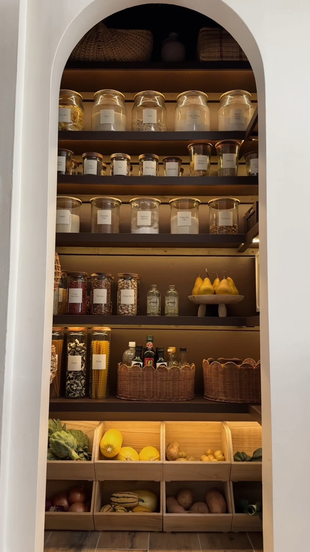 This pantry makeover is still one of my favorite DIYs from 2025. I started by adding 3D-printed arches to the doorway to create an arched pantry entrance — no power tools required, which made this feel very approachable. I chose a warm, moody brown paint color (Barista) and used an affordable paint sprayer to get a smooth finish. Adding LED shelf lighting completely elevated the space and gave it that soft, layered glow.

For styling, I printed custom pantry labels, added glass canisters, rattan hanging baskets, bundles of homegrown herbs, and a little artwork to bring in that cozy European, French-market feel. This is such a great example of how small architectural details, lighting, and thoughtful styling can totally transform a pantry into a space that feels intentional and beautiful.

#LTKstorytime #LTKHome