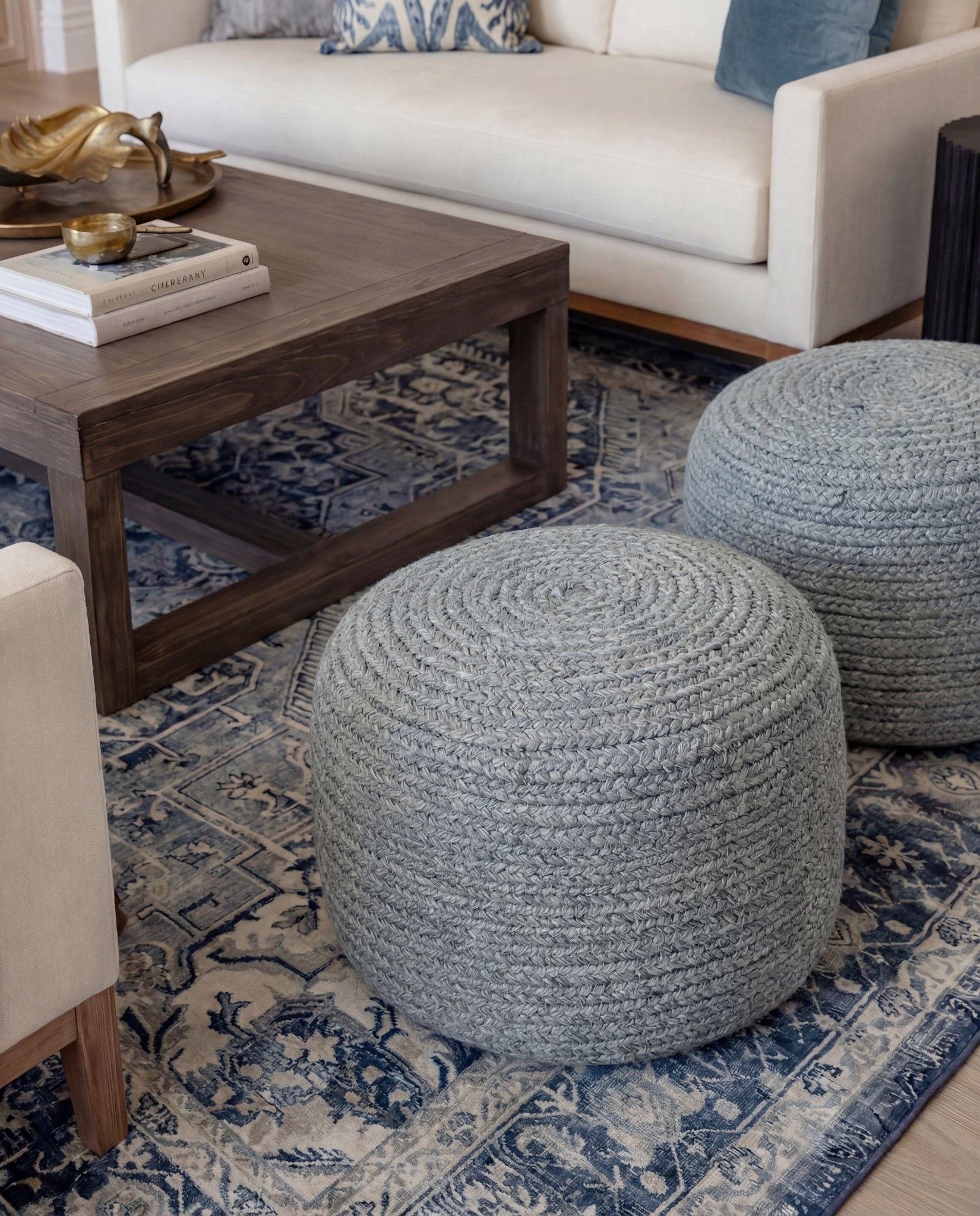 Shop the Look:
• Marble fireplace surround
• Cream armchairs + sofa
• Blue patterned lumbar + throw pillows
• Chunky knit ottomans
• Solid wood coffee table
• Black ceramic vase decor
• Distressed blue traditional rug
• Wood built-ins with glass fronts
• Warm wood ceiling beams
Brown throw blanket 
White decor books
Brass oval tray
Black decor bowl
Rounded globe chandelier 

#LTKHome #LTKFindsUnder100 #LTKSaleAlert