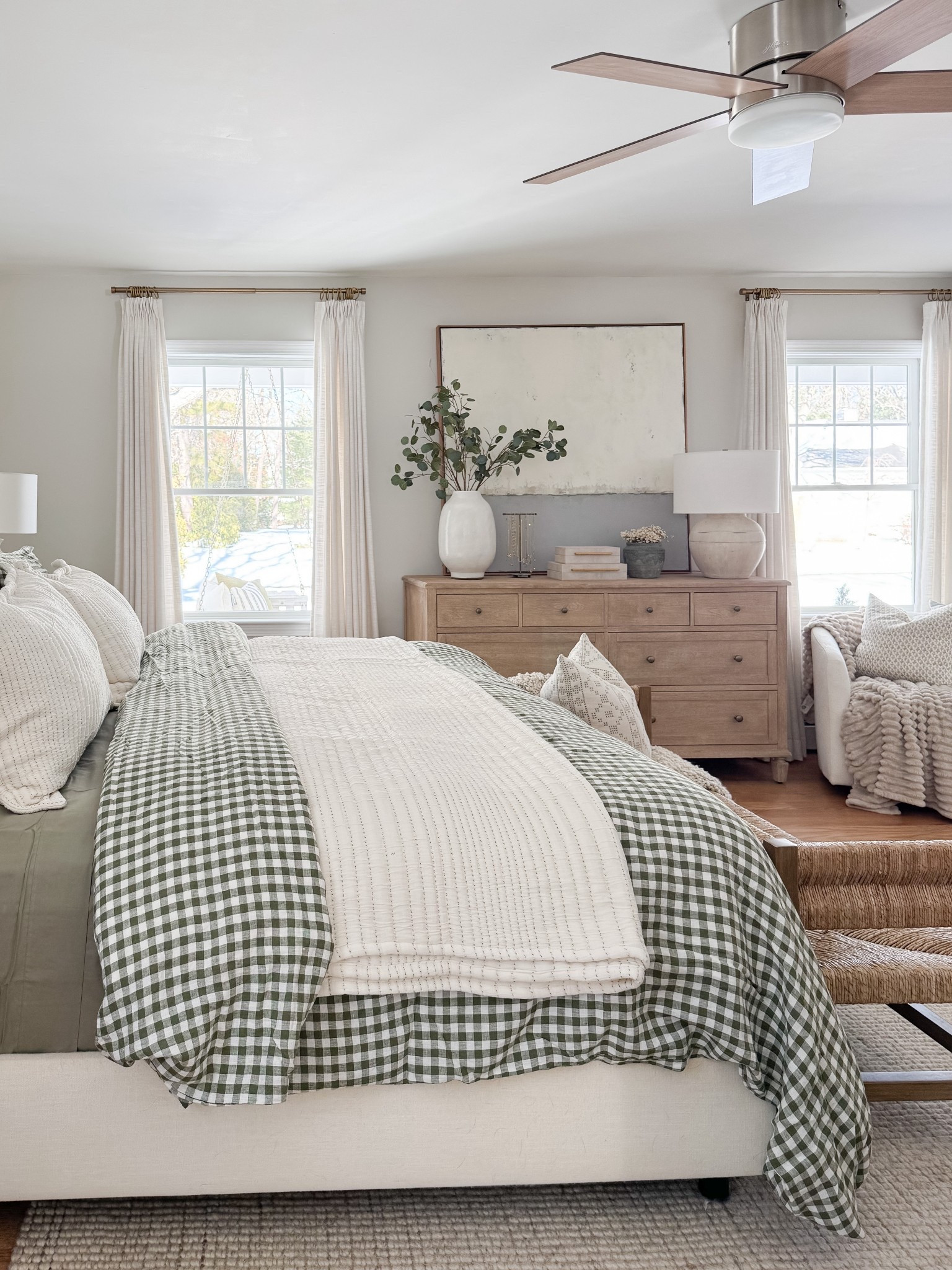 Neutral coastal bedroom with gingham bedding, layered throw blankets, textured knit coverlet, and soft patterned pillows. Light wood nightstands and white table lamps create a calm, layered spring bedroom look. 
gingham bedding, neutral bedroom decor, layered bedding, spring bedding, coastal bedroom, throw blanket, knit coverlet, patterned pillows, light wood nightstands, white table lamps, cozy bedroom, serene bedroom style, sherri calnan home

#LTKHome