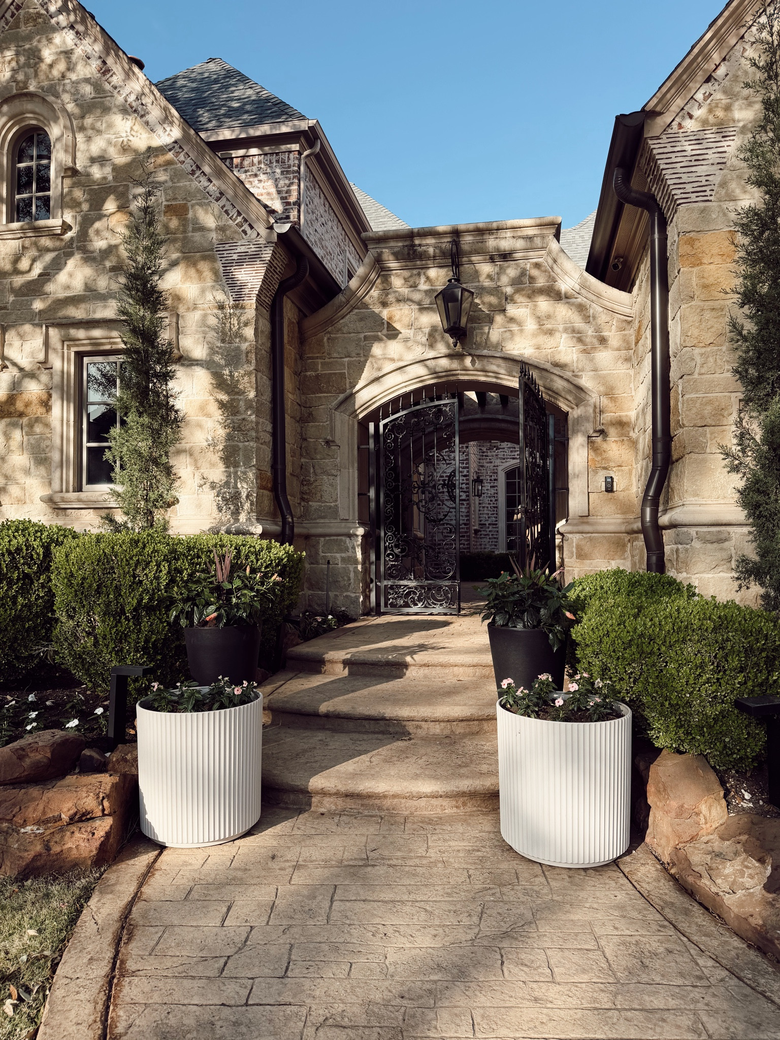 Front porch goals. The stone exterior, oversized planters, and layered greenery make this entryway feel so timeless and high end. I love how simple neutral outdoor decor can completely elevate the look of your home while still feeling warm and inviting. Such pretty inspiration for summer curb appeal and outdoor styling.

#LTKSeasonal #LTKHome