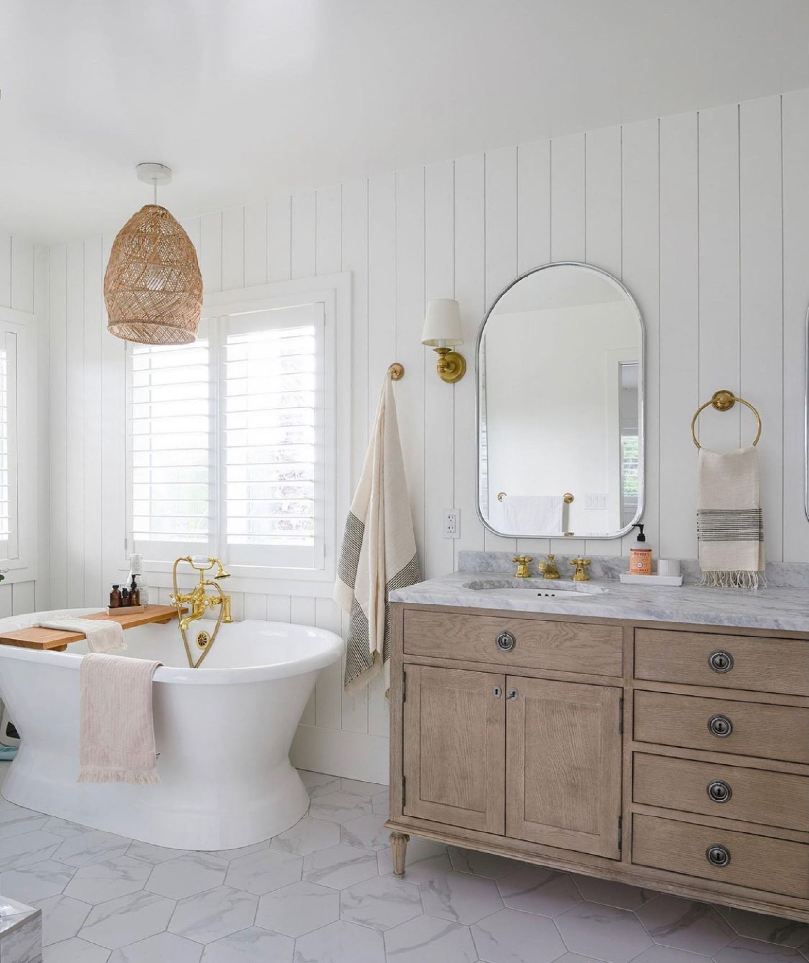 Love the way this primary bath turned out! The free standing tub is the perfect spot for some relaxation! The brass accents, wood double sink vanity, and rattan pendant light bring warmth to the space.

#LTKMostLoved #LTKhome