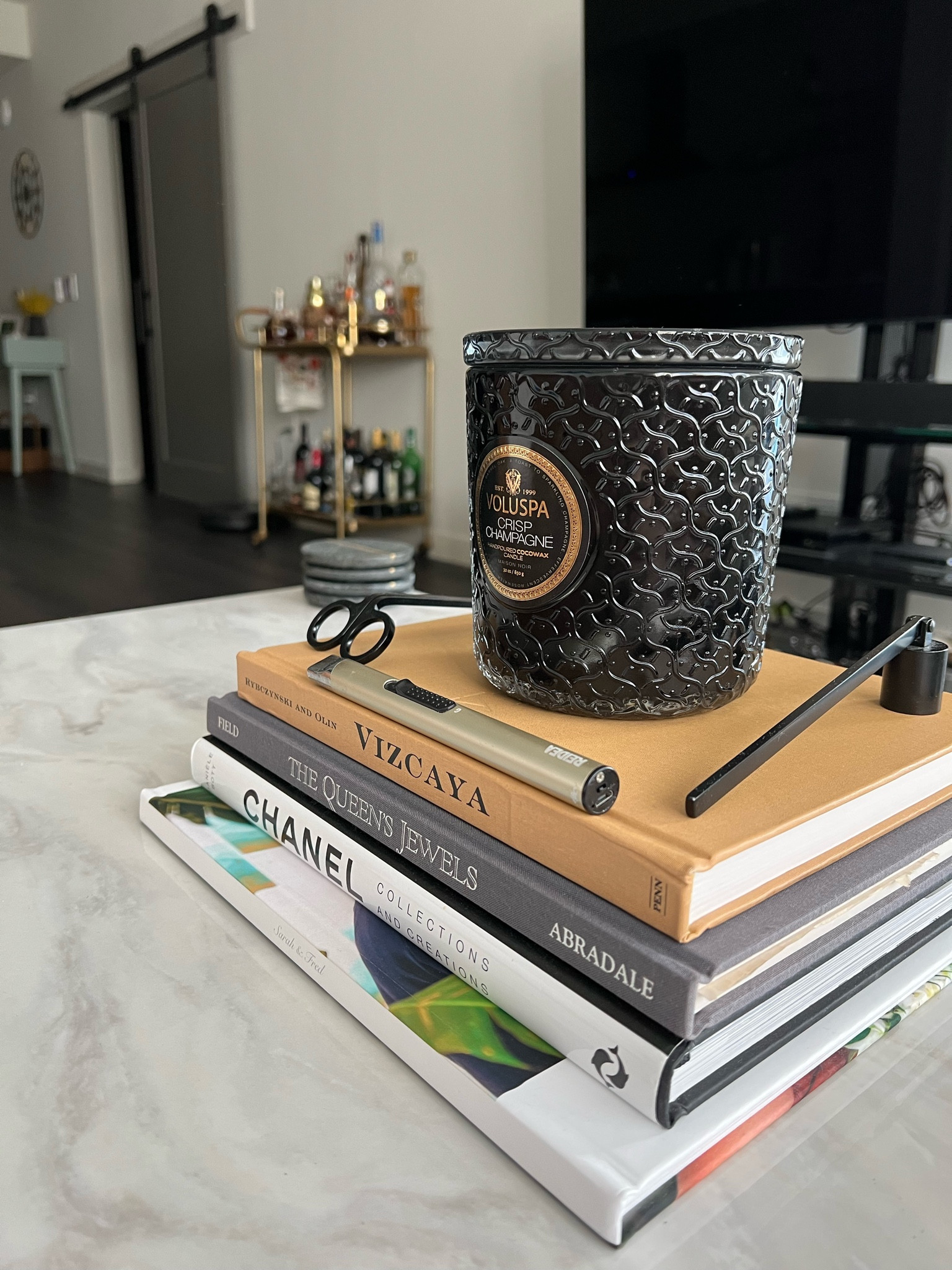 Coffee table decor 
White marble coffee table 
Chanel coffee table book 
Electric lighter 
Black Candle snifter 
Black Wick trimmer 
Voluspa 3 wick crisp champagne candle
Marble coasters 

#LTKhome #LTKstyletip