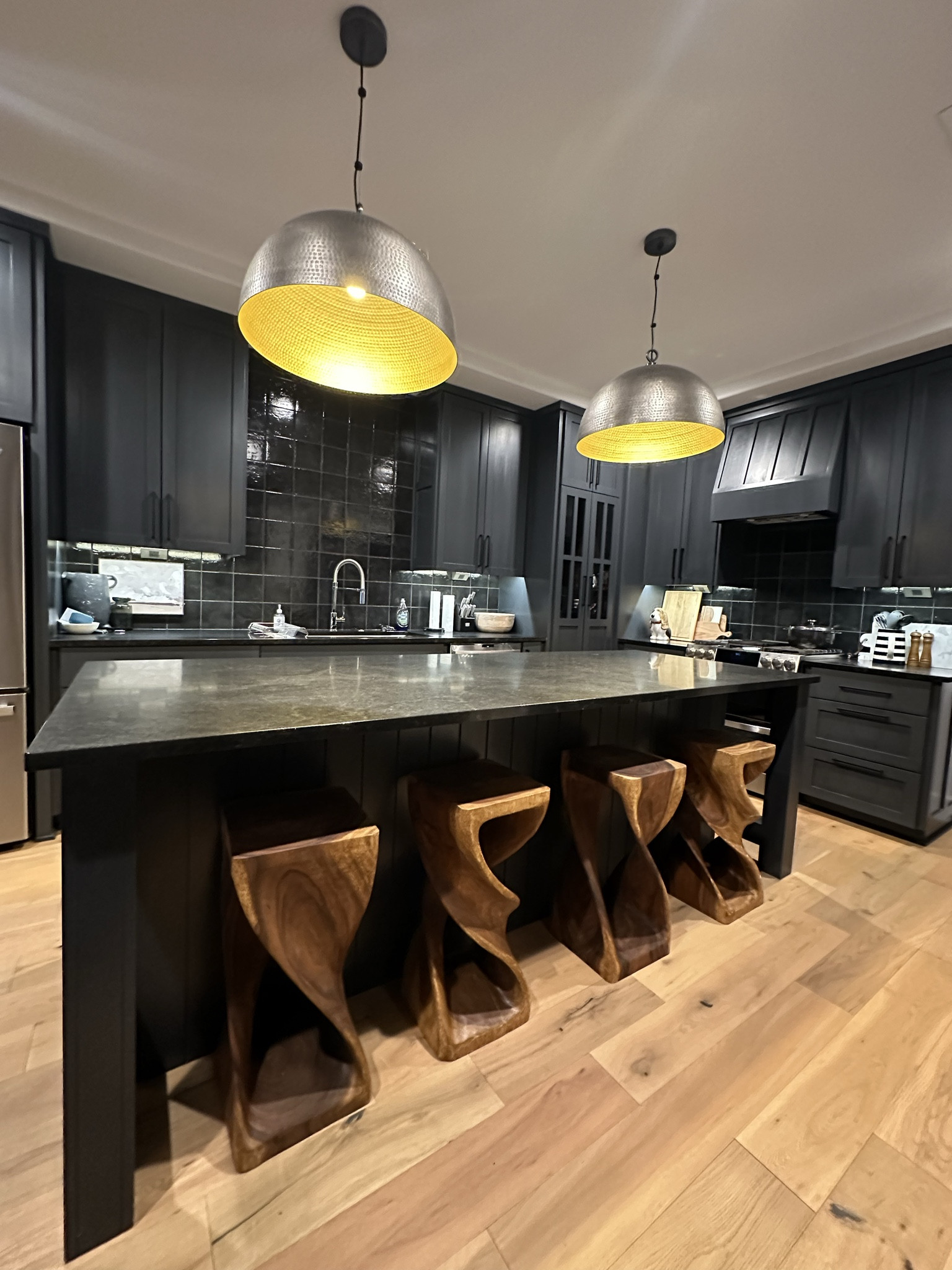 All black kitchen? Yes please! Still in love with the moody vibes of our farmhouse kitchen renovation. ❤️ 

Black kitchen, dome pendants, wood barstools, black granite, black tile backsplash, black cabinets 

#LTKhome