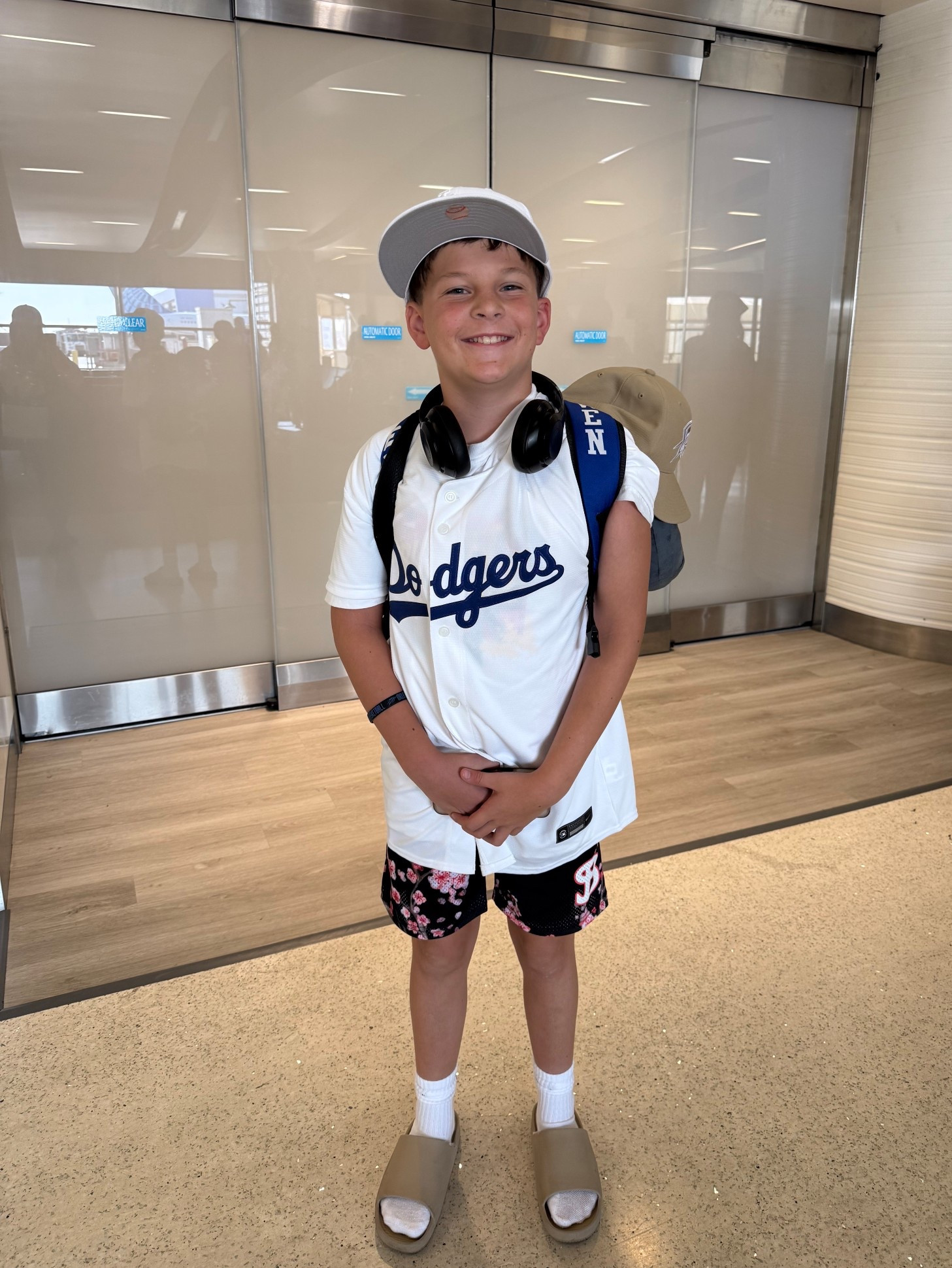 Where do we go next? After a summer full of work, we’re recapturing family time wherever we can. This boy loves to travel, and nothing makes him happier than new adventures on the go! 💙 #FamilyTravel #BoyMom #TravelStyle

Outfit details: He’s wearing a classic Los Angeles Dodgers youth baseball jersey paired with athletic floral shorts for a sporty yet fun vibe. On his feet, he’s rocking the always-trendy slides with white crew socks, perfect for airport comfort. Accessories include a flat-brim snapback hat, a backpack for travel essentials, and wireless over-ear headphones—a must-have for stylish and practical travel looks. #KidsTravelStyle #BoysOutfitInspo #AirportStyle #YouthAthleisure

#LTKFamily #LTKKids #LTKTravel