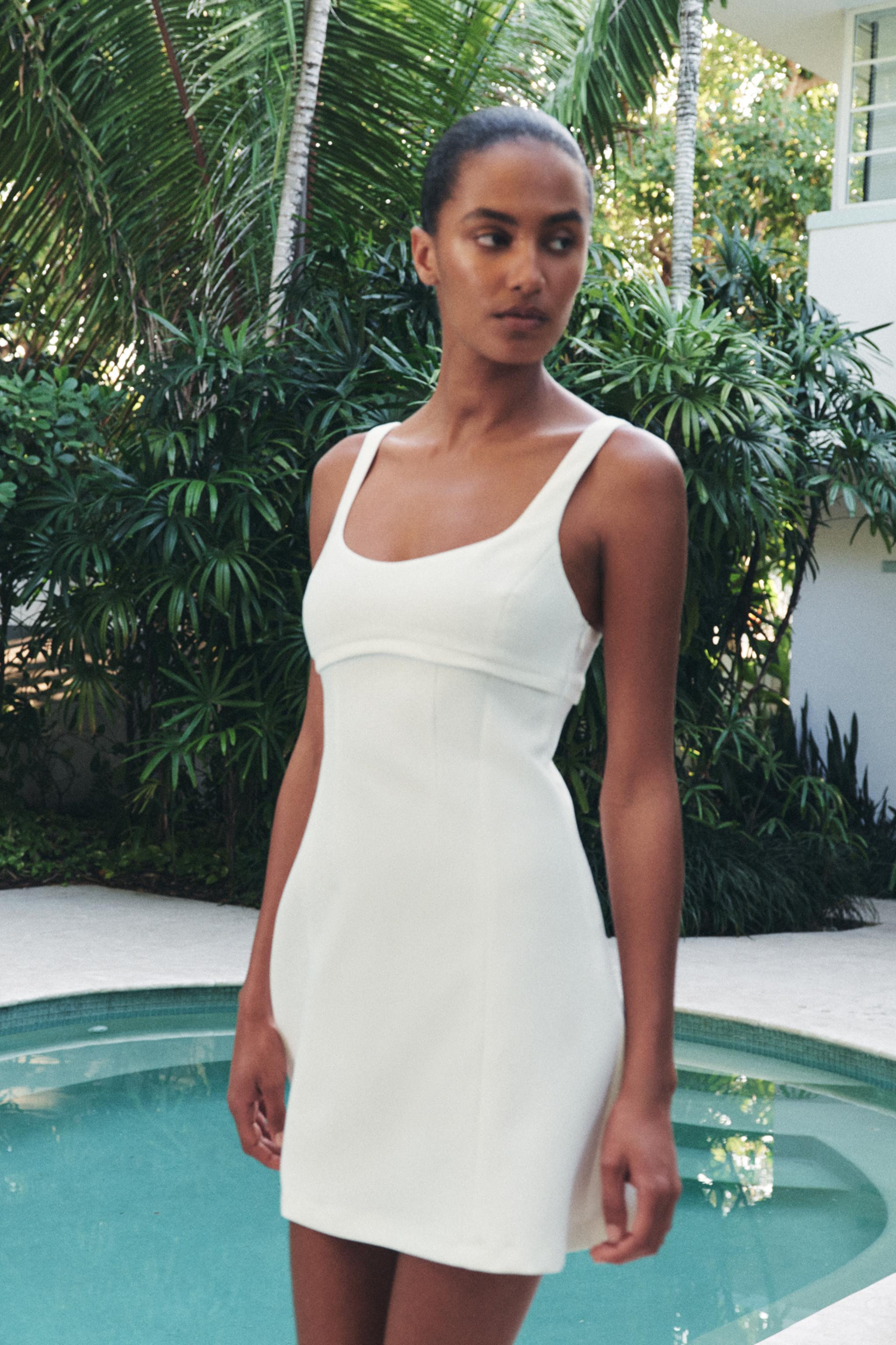Dress with a round neckline and wide straps. Fitted waist and opening at the back. Flared hem. Co... | Zara UK